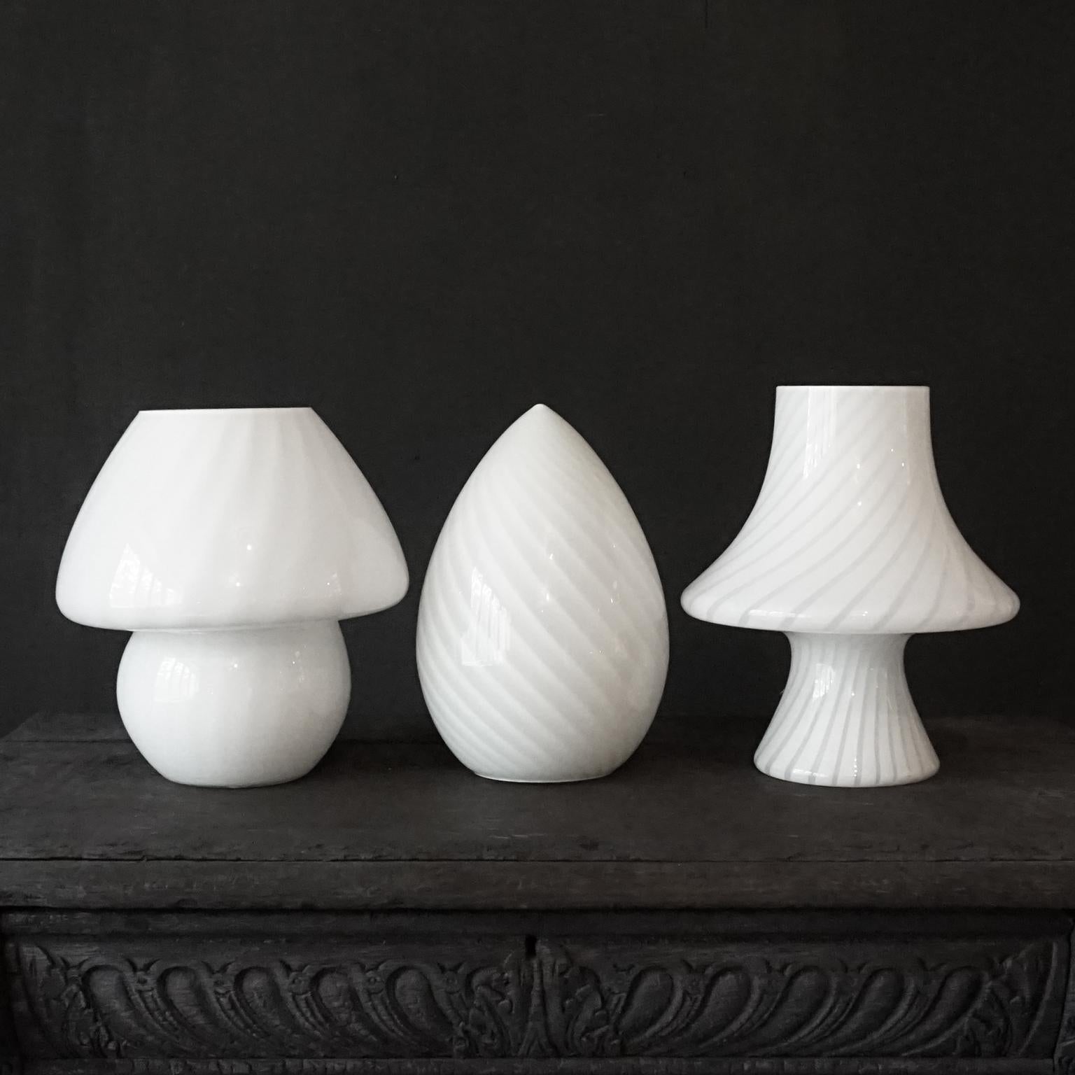 Gorgeous set of three vintage Hollywood Regency style 1980s medium size Murano white cased swirl art glass lamp shades. Two mushrooms models and an egg model.

Made of hand blown frosted cased glass. With opaque white and clear swirls. 
It looks