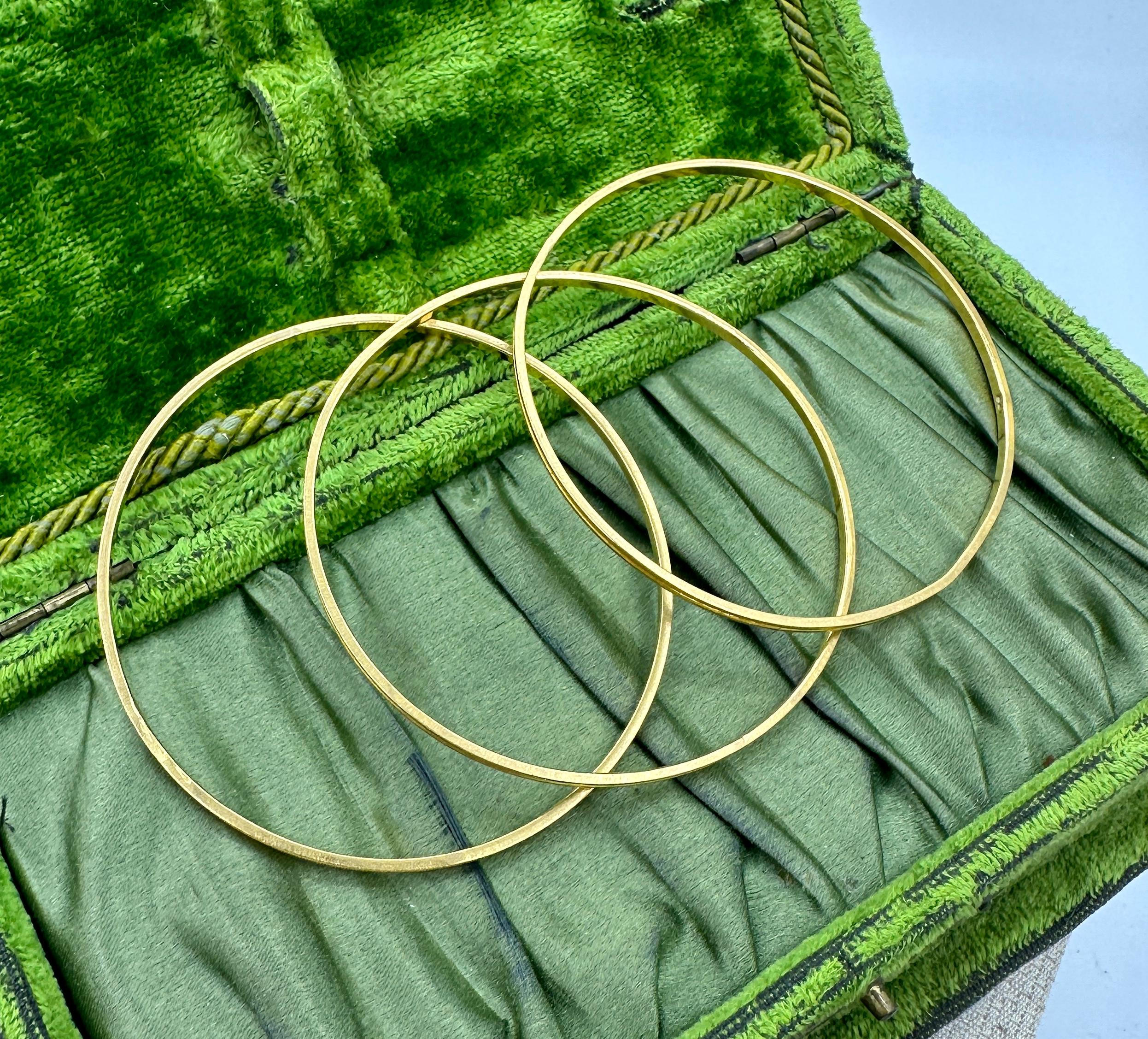 This is a wonderful and classic trio of three Bangle Bracelets in 22 Karat Yellow Gold.  The classic stacking Bracelets have stunning design with rectangular engraving and detailed borders.  The bracelets are period jewels with clean modern lines