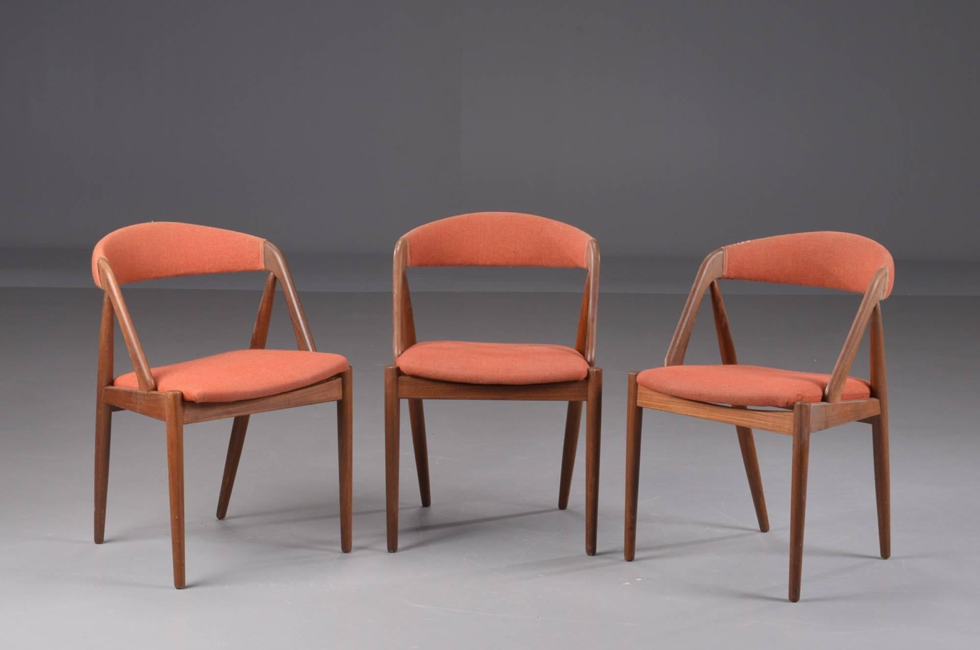 Three A-frame model 31 chairs designed by Kai Kristiansen for Schou-Andersens Møbelfabrik. Set of fined teak wood. Seat and back upholstered with red fabric.
