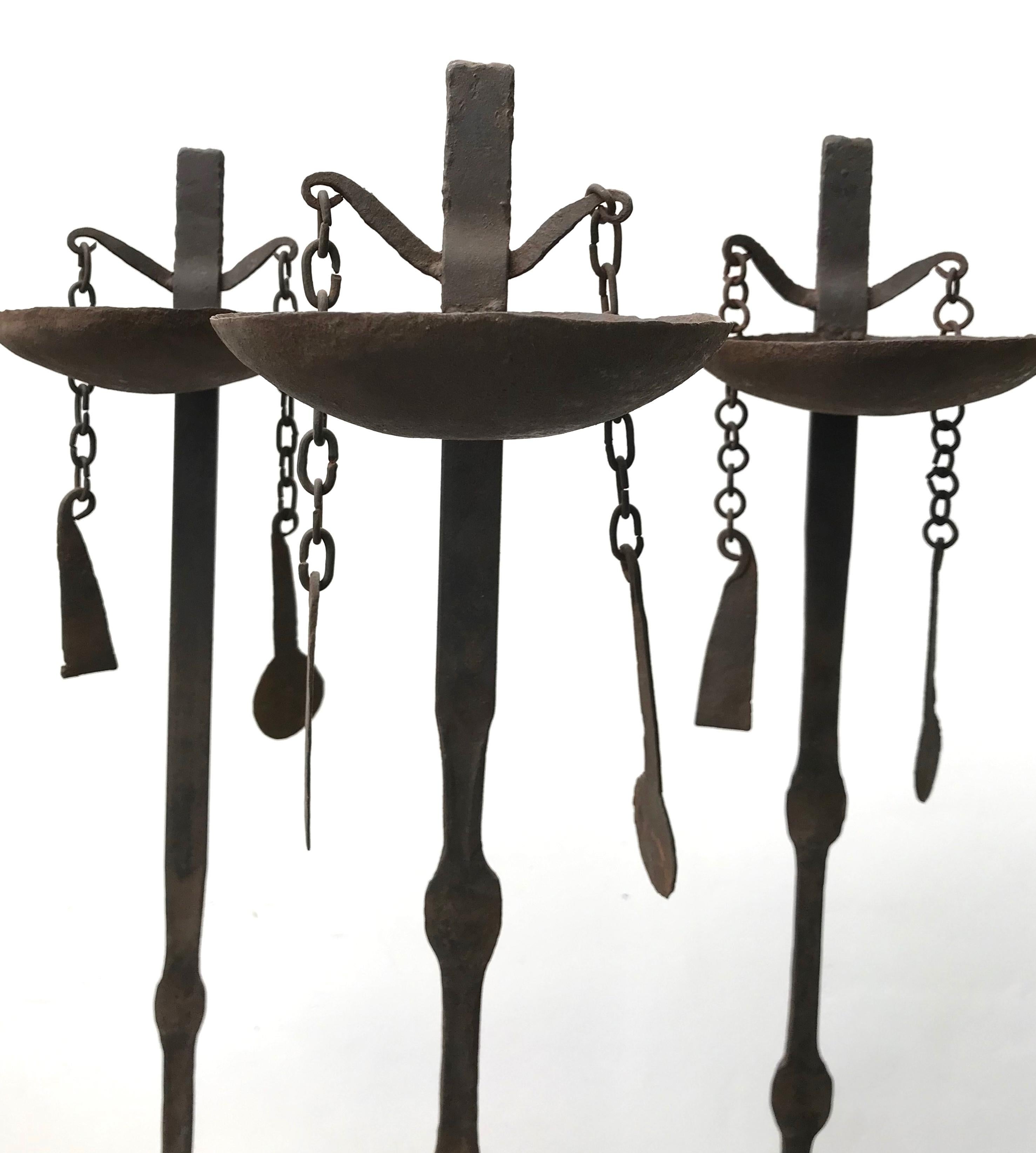 A group of three African Dogan hand forged iron oil lamps. These oil lamps are made to stick in the ground and fill with oil and a floating wick for ceremonial use.
We have had the lamps mounted on to mental stands so they can stand on their own.