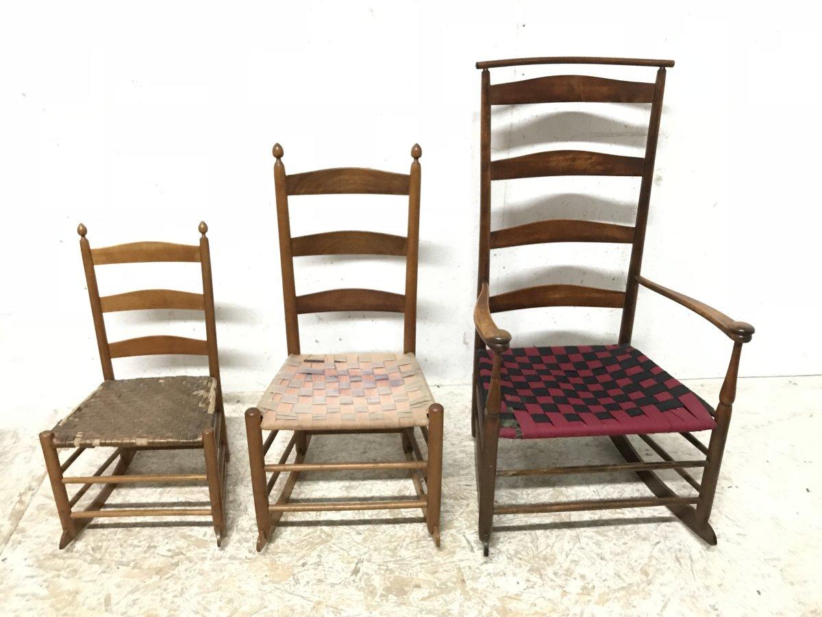 A rare set of three American Shaker, ladder back rocking chairs.
All three came together and are made from Maple.
The tall ladder back armchair, has a shawl rail to the top with a fabric webbed seat.
Retaining the original stamp to the back of