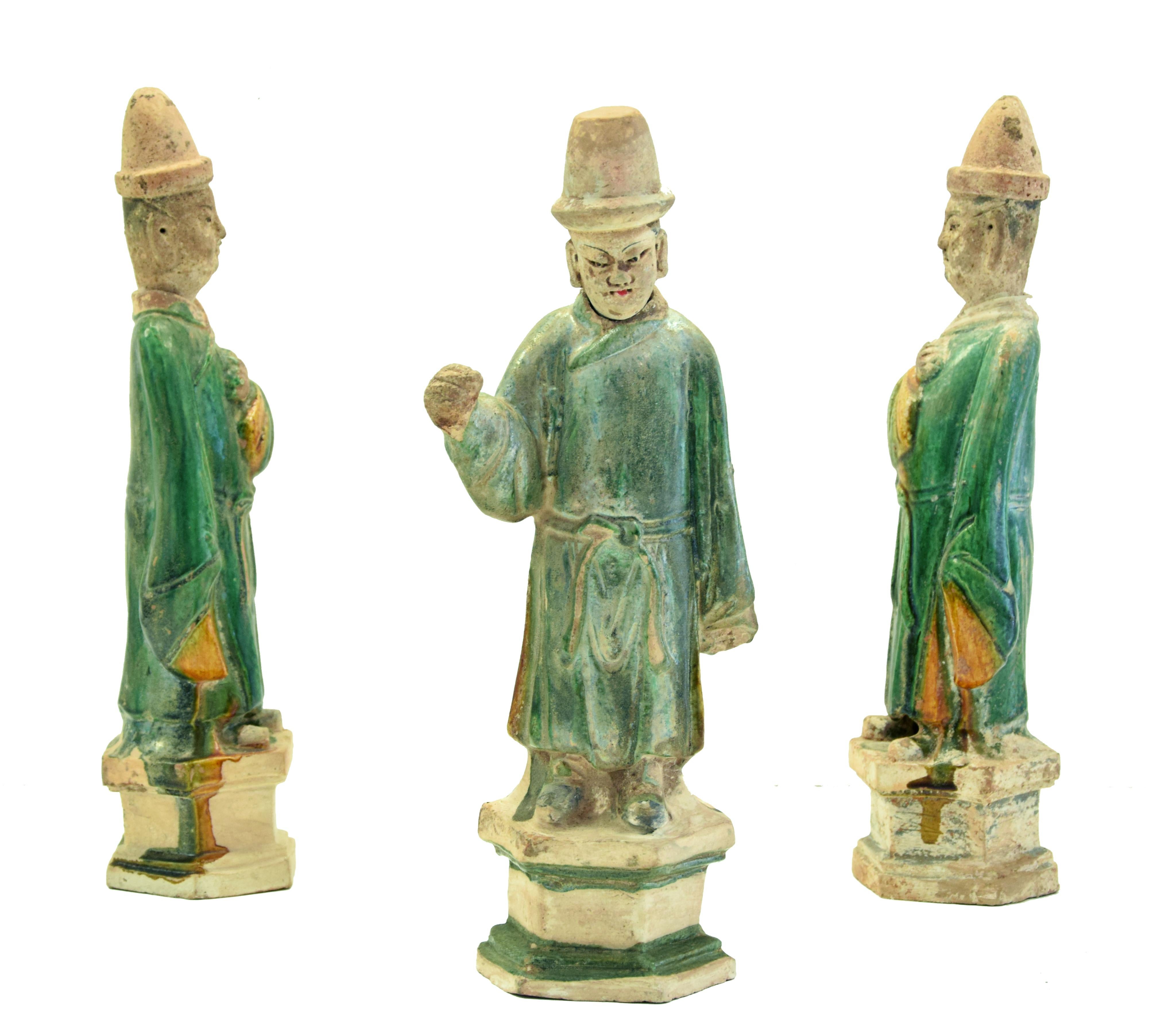 This Chinese terracotta group of figures is made up of three figures of Chinese dignitaries in glazed green and ocher terracotta on hexagonal bases and removable heads.

From the dresses with wide sleeves and workmanship, as well as from the