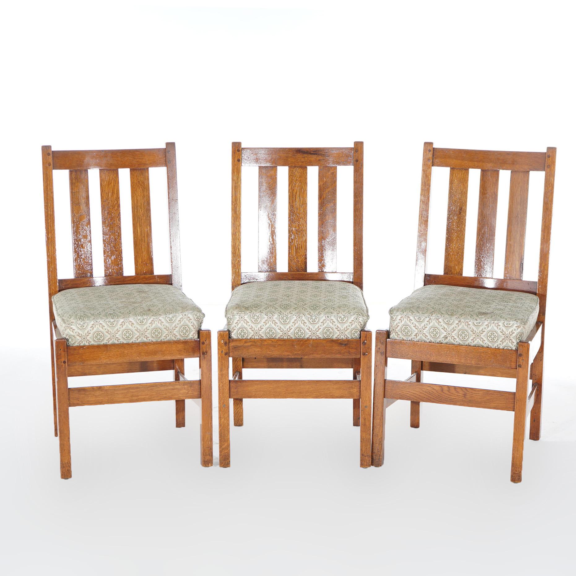 A set of three antique Arts and Crafts side chairs by L & JG Stickley offer oak construction with slat backs, upholstered seats and raised on straight square legs, c1910

Measure - 37