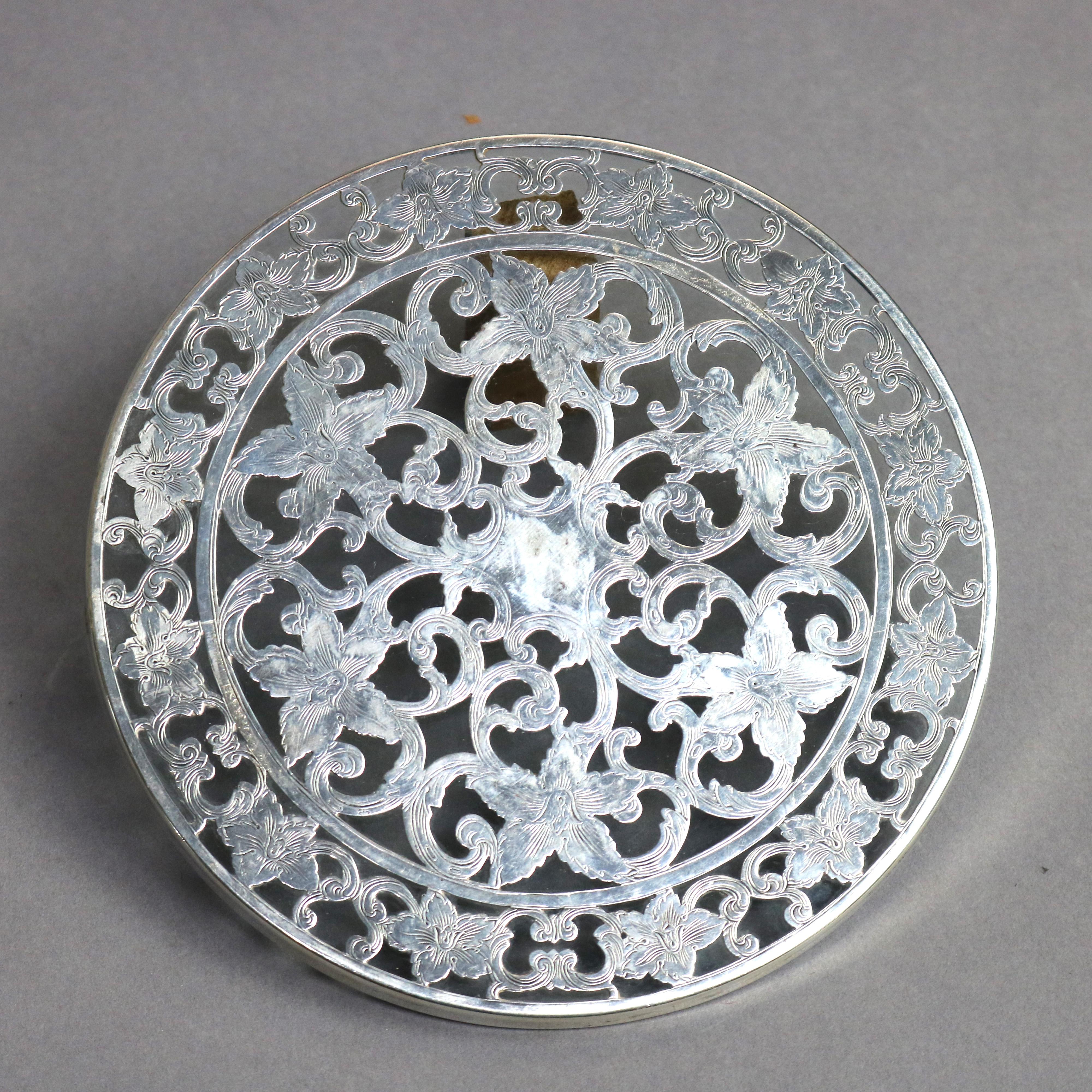 Three antique glass trivets offer reticulated sterling silver overlay with scroll and foliate design, circa 1890

Measures- (1)- 0.25