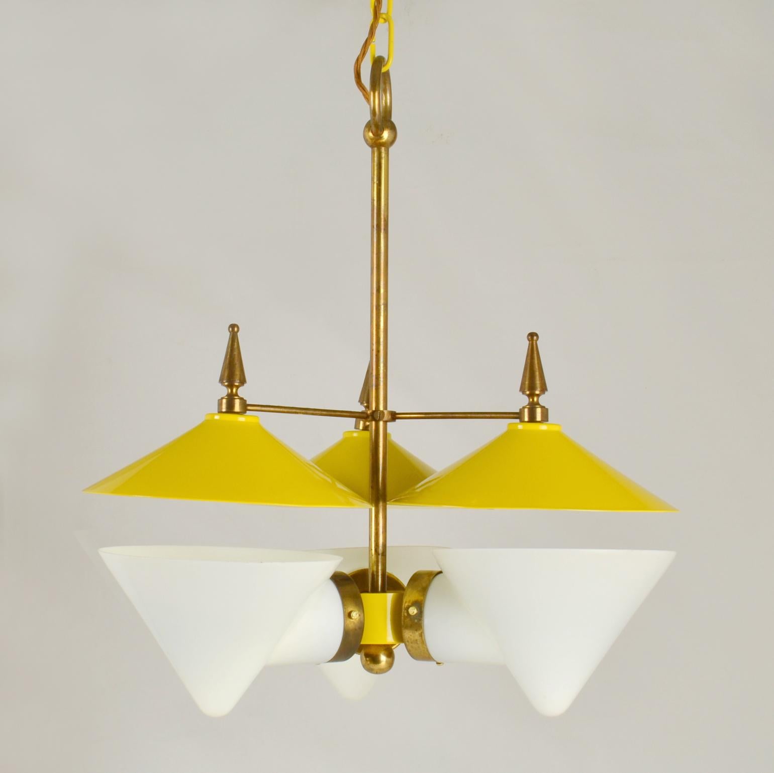 Extraordinary rare three arm 1950's French chandelier featuring a double conical shade made in two parts, the bottom part in opal glass and the cone shape reflector spun in lemon yellow enameled aluminum with brass details and fixtures is attributed
