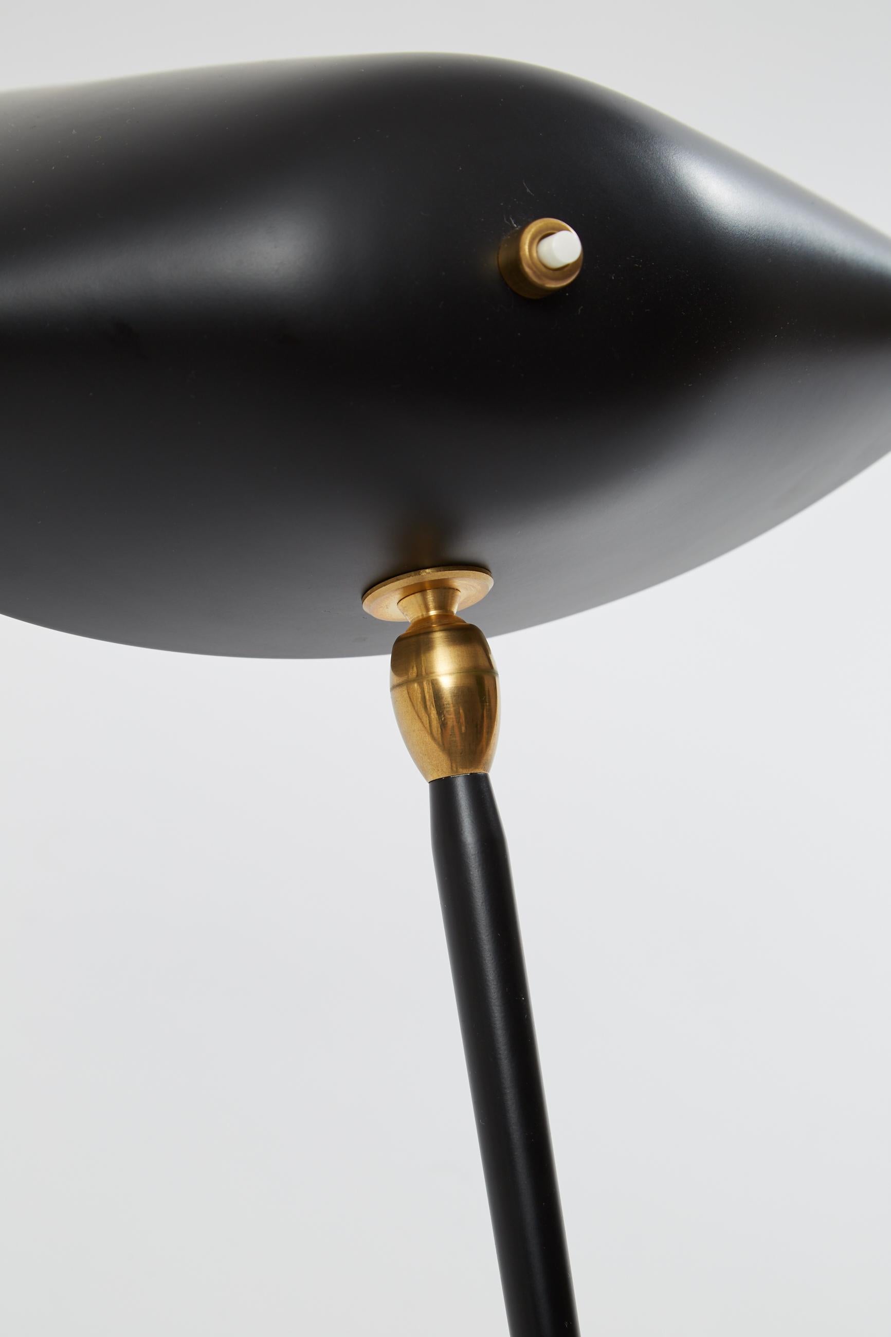 Three-arm floor lamp by Serge Mouille. Originally designed by Serge Mouille in 1952. This light is a licensed re-edition from the “Black Shapes” series currently manufactured by Editions Serge Mouille in France. Steel and painted black base, with