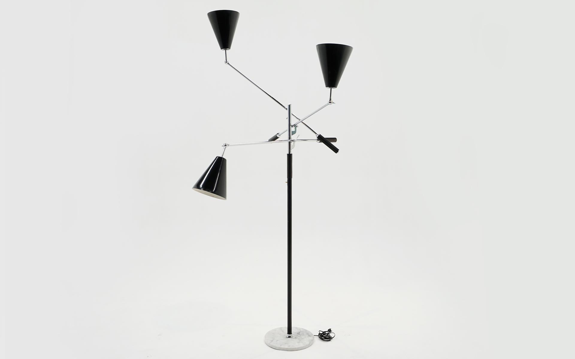 Classic three arm Italian adjustable floor lamp in the style of Arredoluce. For years these lamps were attributed to Arredoluce. Chromed steel independently adjustable arms with black leather covered handles, black shades, and a round white marble