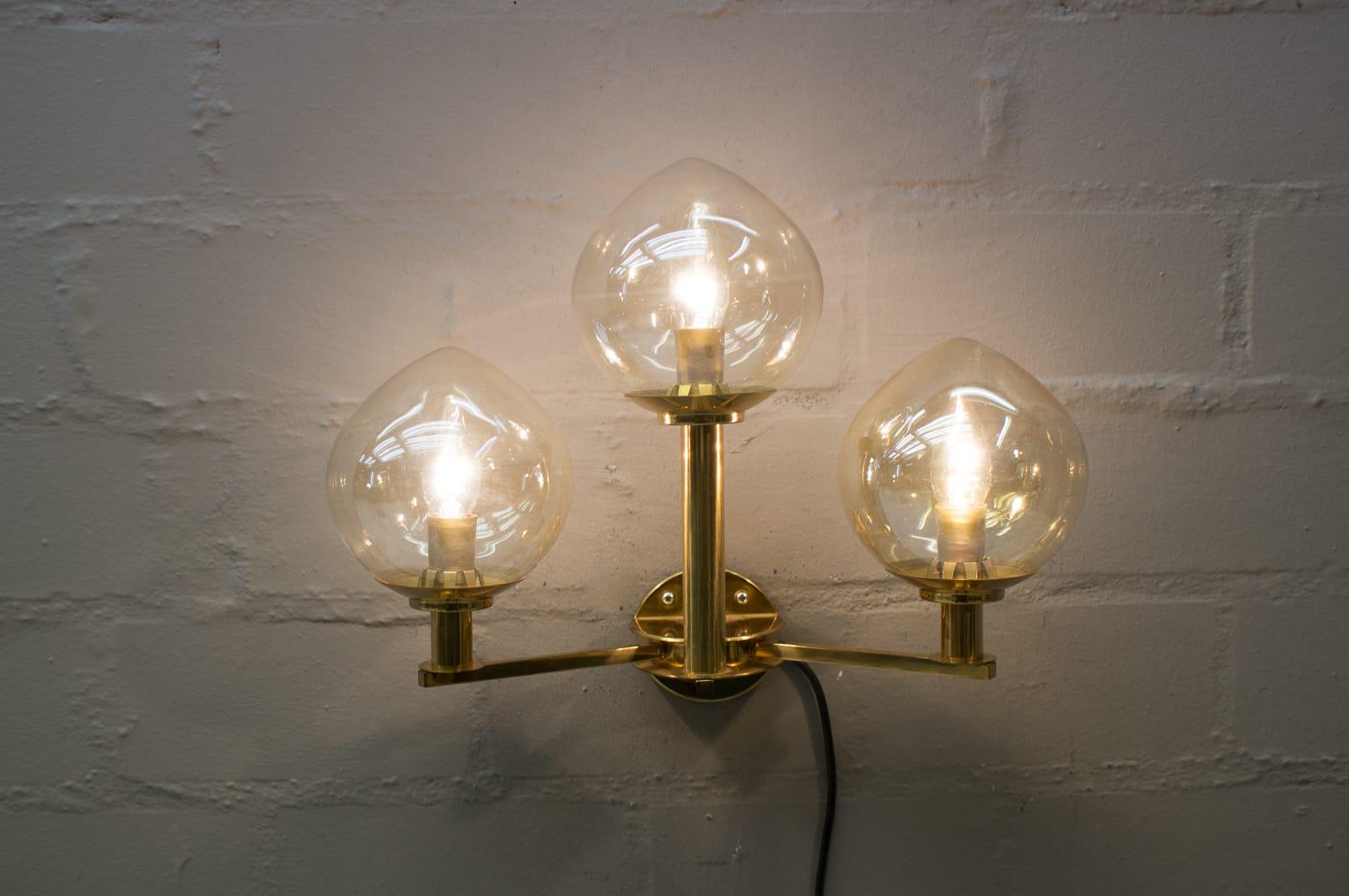 Elegant Mid-Century Modern wall lamp. 

Designed probably by Hans-Agne Jakobsson for Markaryd, Sweden in 1960s.

Executed in massive brass. The chandelier needs 3 x E14 Edison screw fit bulb.

They are wired, in working condition and run both