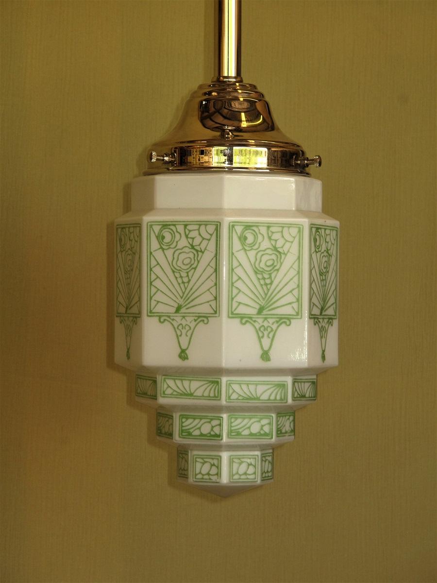 Wonderful vintage deco inspired green stenciled design fired onto a milk glass globe. On the modest size with the shade itself is 9 inches high and 6 inches wide. Shown on a new nickel plated fitter. Overall drop with fitter shown is 19 inches. Drop