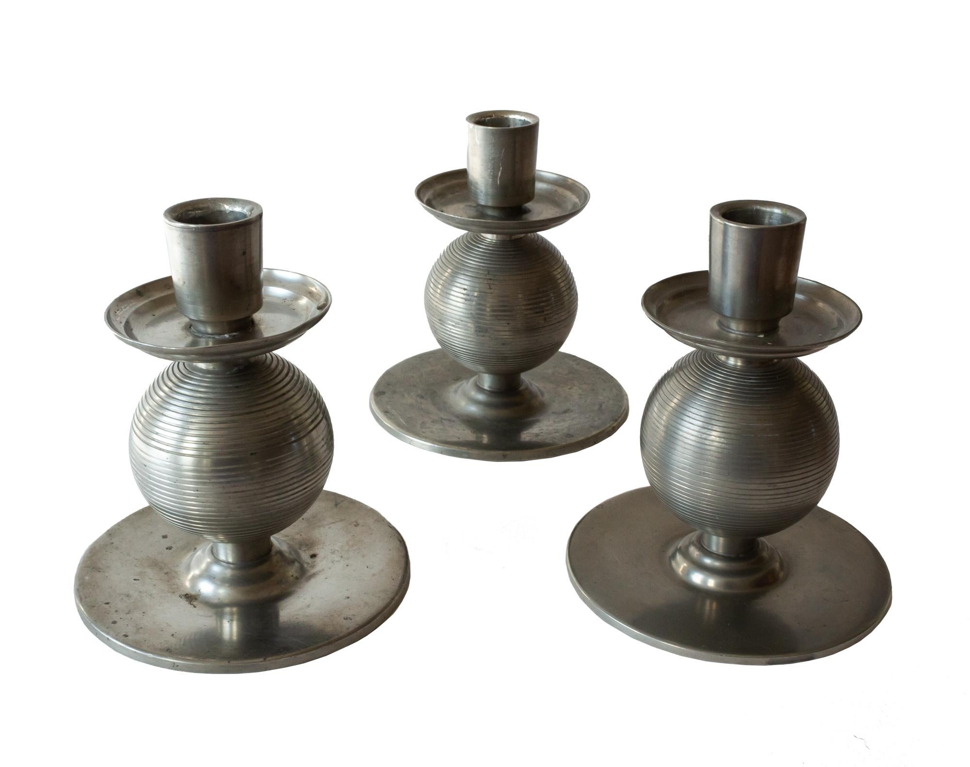 Three elegant, functionalist Art Deco pewter candlesticks by Nils Fougstedt made 1937. Embossed stripes around the sphere. Signed and stamped Nils Fougstedt and FAK, L8, Svenskt Tenn. Measures: Height 13.5, sphere 6, and the base 12 cm.
In 1924,