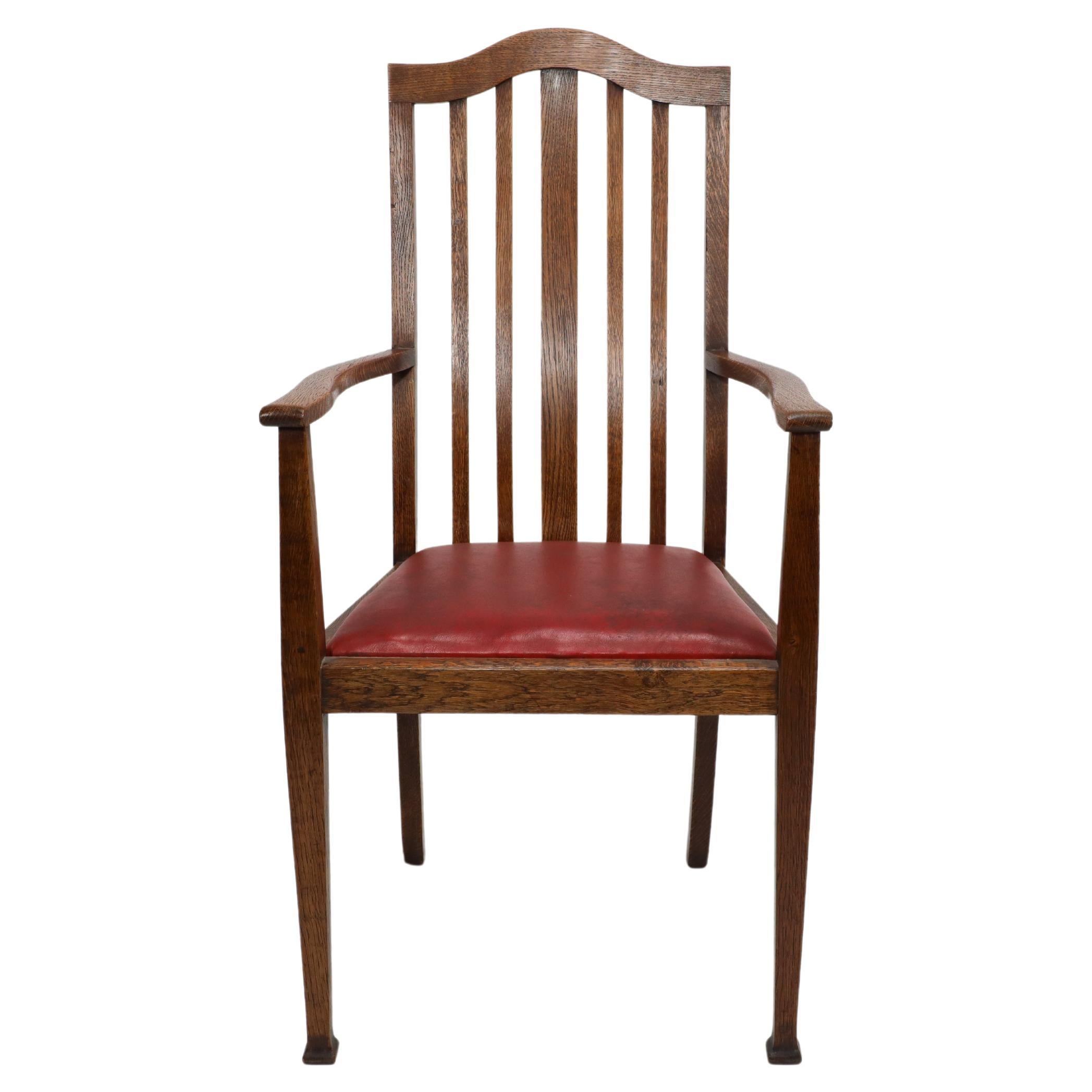 Three Arts and Crafts oak dining armchairs with arched tops and shaped slats to the back making them very comfy armchairs. Professionally recovered in a quality wine coloured leather.