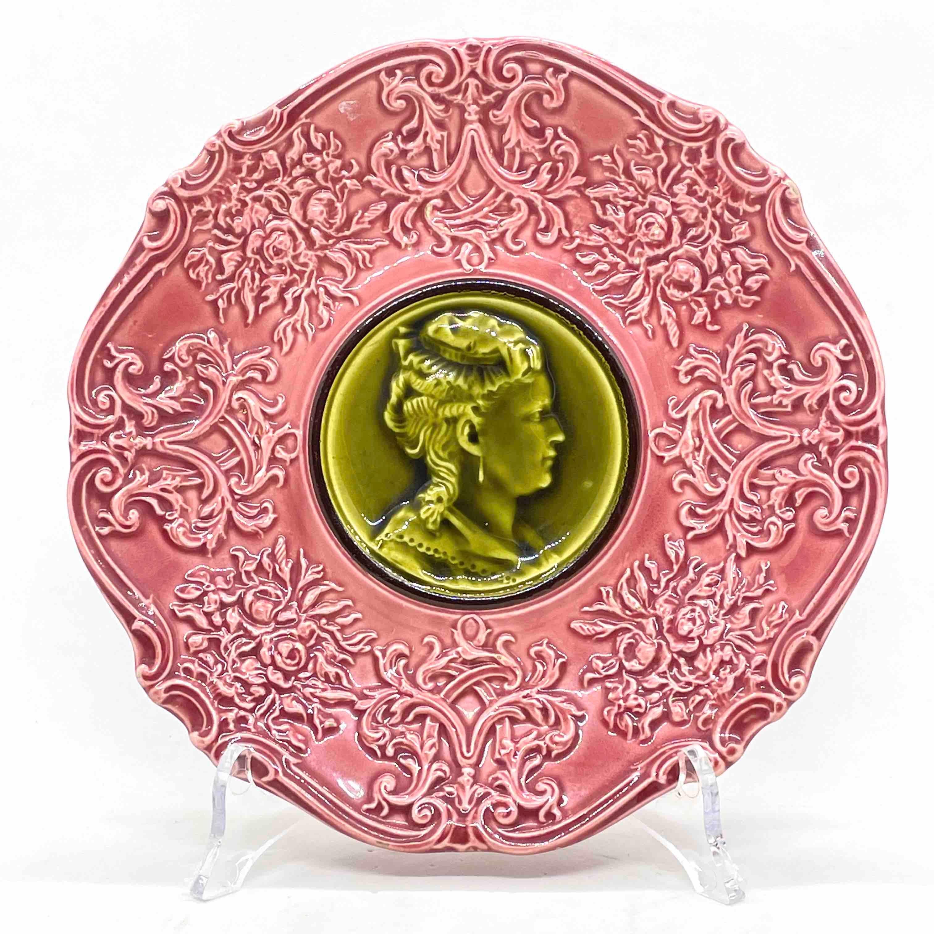 19th century majolica plates by Villeroy & Boch in unusual color combination of olive green and majolica pink with relief design on front. Nice addition to your table or just to display. Please see detailed pictures for antique as found condition.