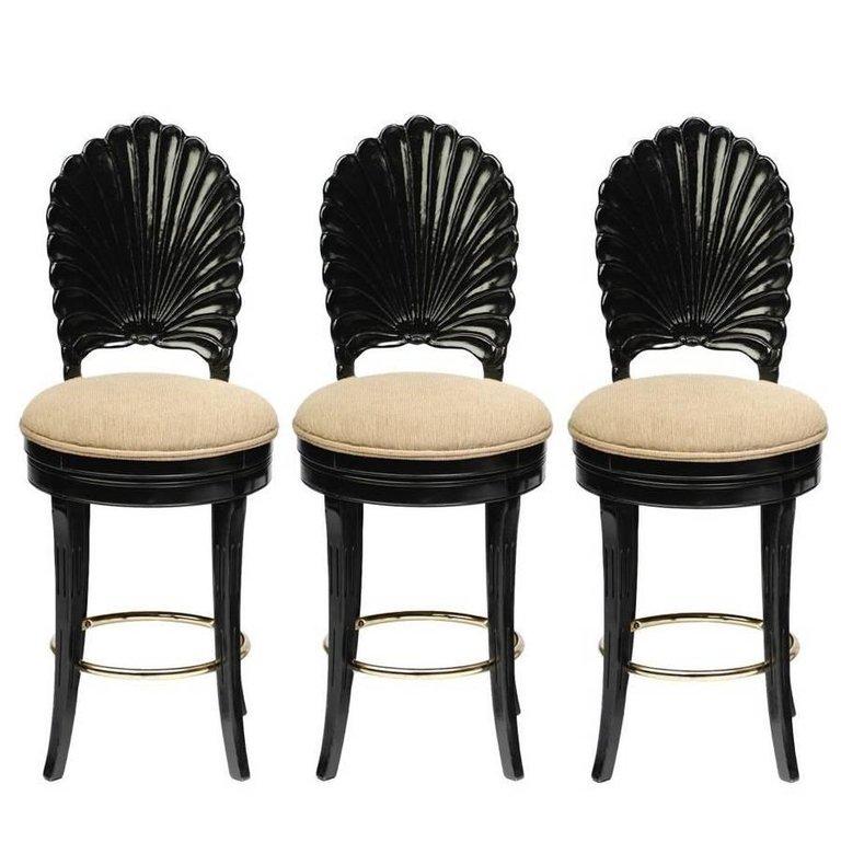 Three elegant Italian Venetian Grotto shell back swivel bar stools. Each chair was handmade with extra attention and features solid wood frames with a black lacquer finish, a scalloped shell motif back with tan color upholstered swivel seats. The