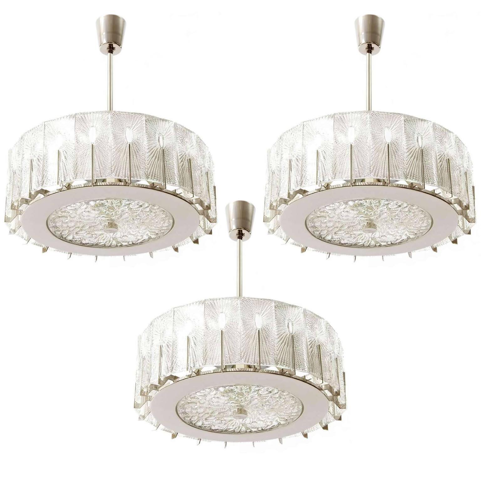 A set of three beautiful textured glass and nickel (similar to chrome) light fixtures by Rupert Nikoll, Austria, manufactured in midcentury, circa 1960 (late 1950s or early 1960s). The glass structure is in the style of the lights from J.T. Kalmar