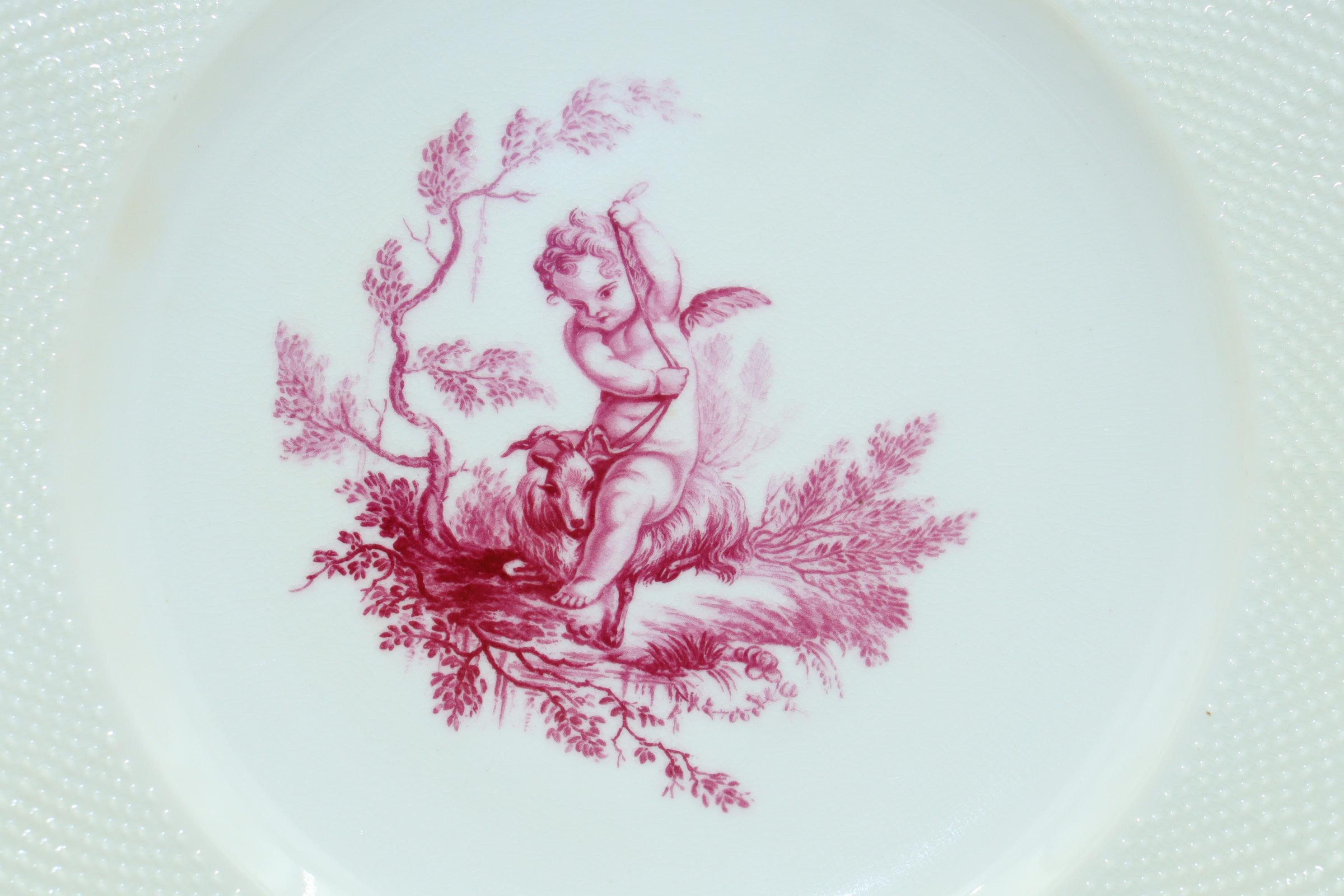 These three Minton porcelain plates are decorated very simply, but strikingly, with central hand coloured transfer prints of cherubs which have done in puce. The pattern number is G 1533 and is shown in the Minton archives as 'Pink Cupids by John
