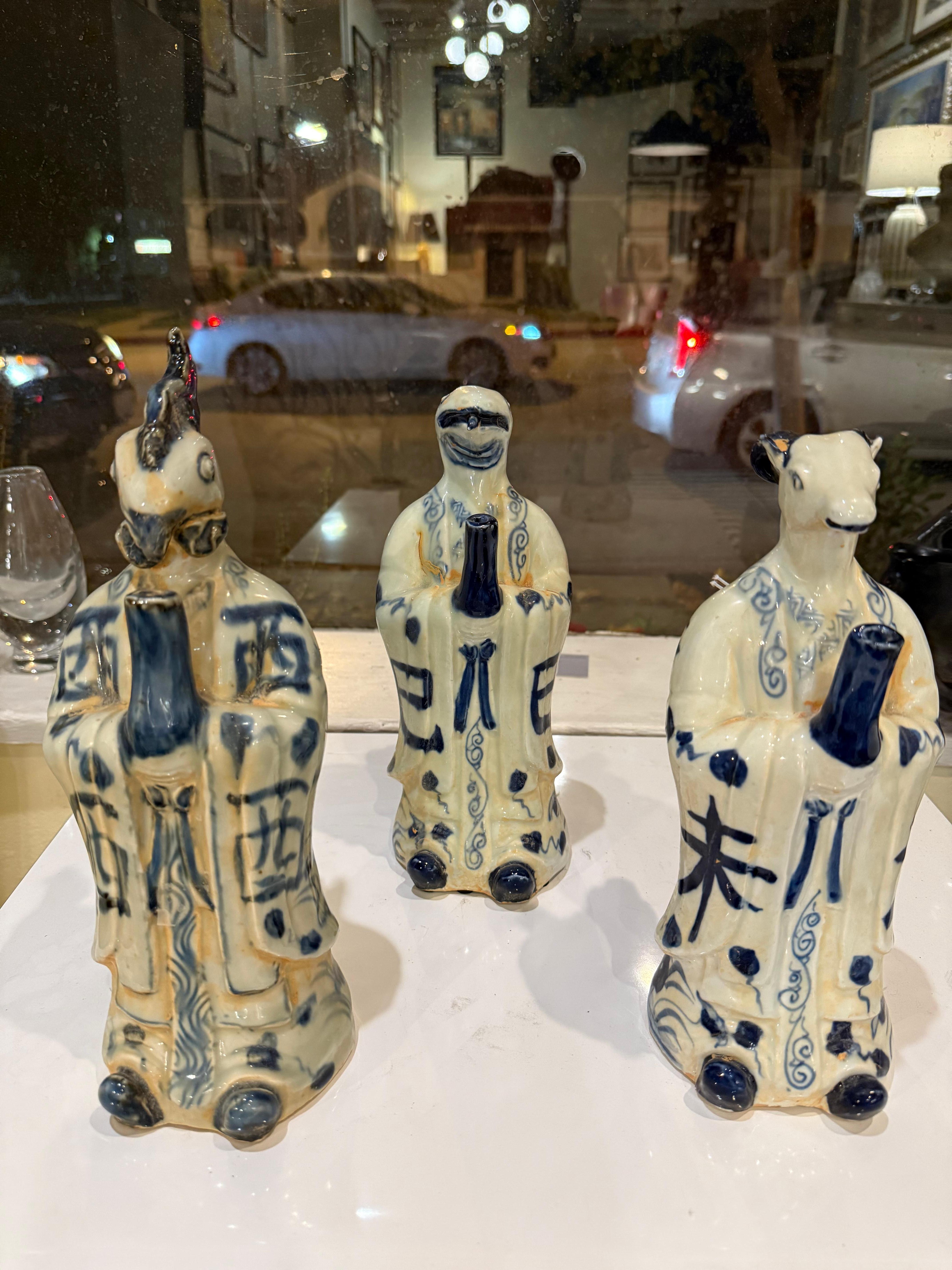 Un charmant trio de figurines en céramique peintes à la main, représentant chacune un animal du Zodiac chinois : le Serpent, le Coq et la Chèvre. Rendues dans une glaçure expressive bleue et blanche, les figures combinent un caractère folklorique