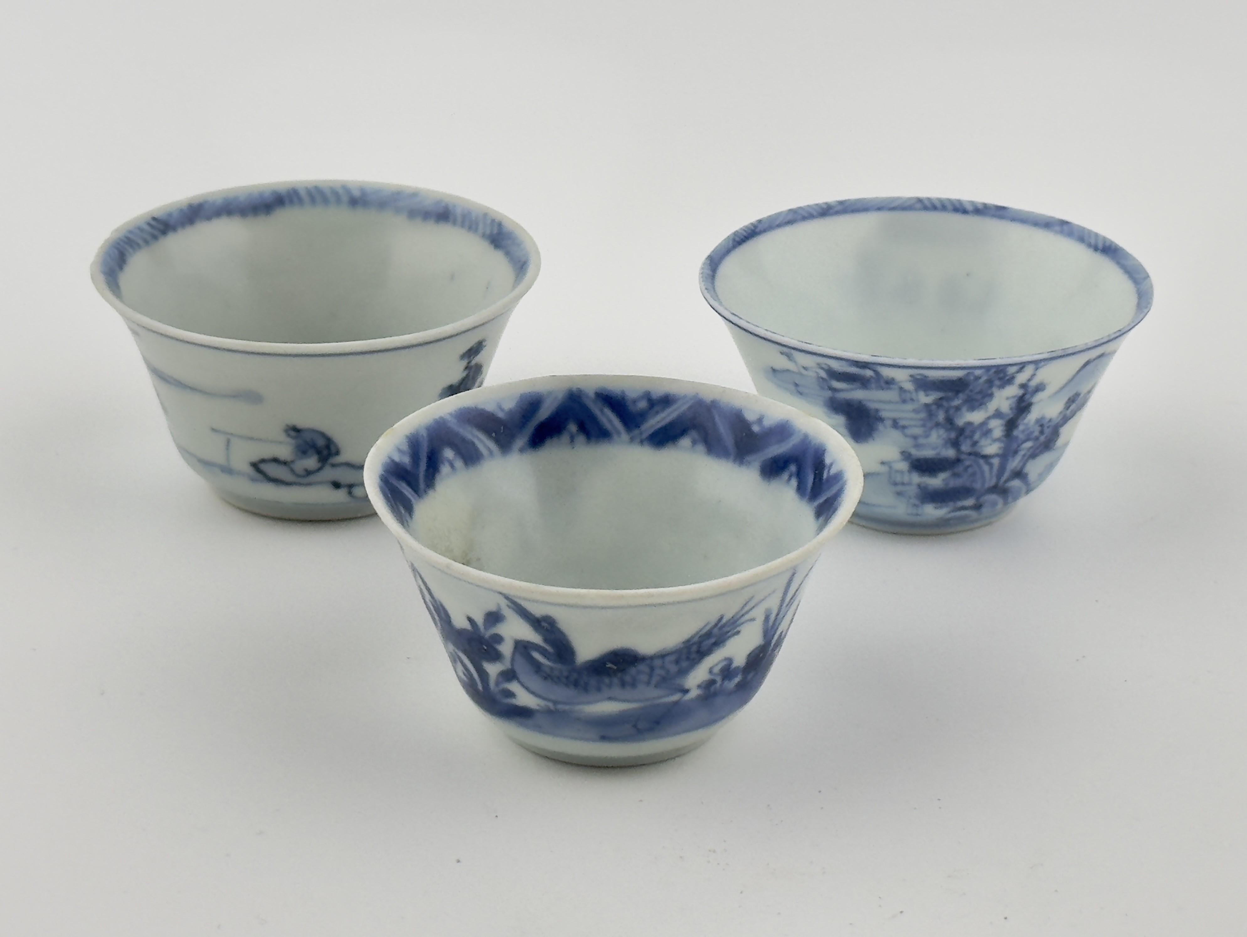 L'œuvre de gauche est une tasse à thé classique en porcelaine bleue et blanche, ornée d'une délicate scène de paysage. L'extérieur de la coupe présente des détails complexes d'arbres, de maisons, de montagnes et d'eau, tous représentés dans des tons