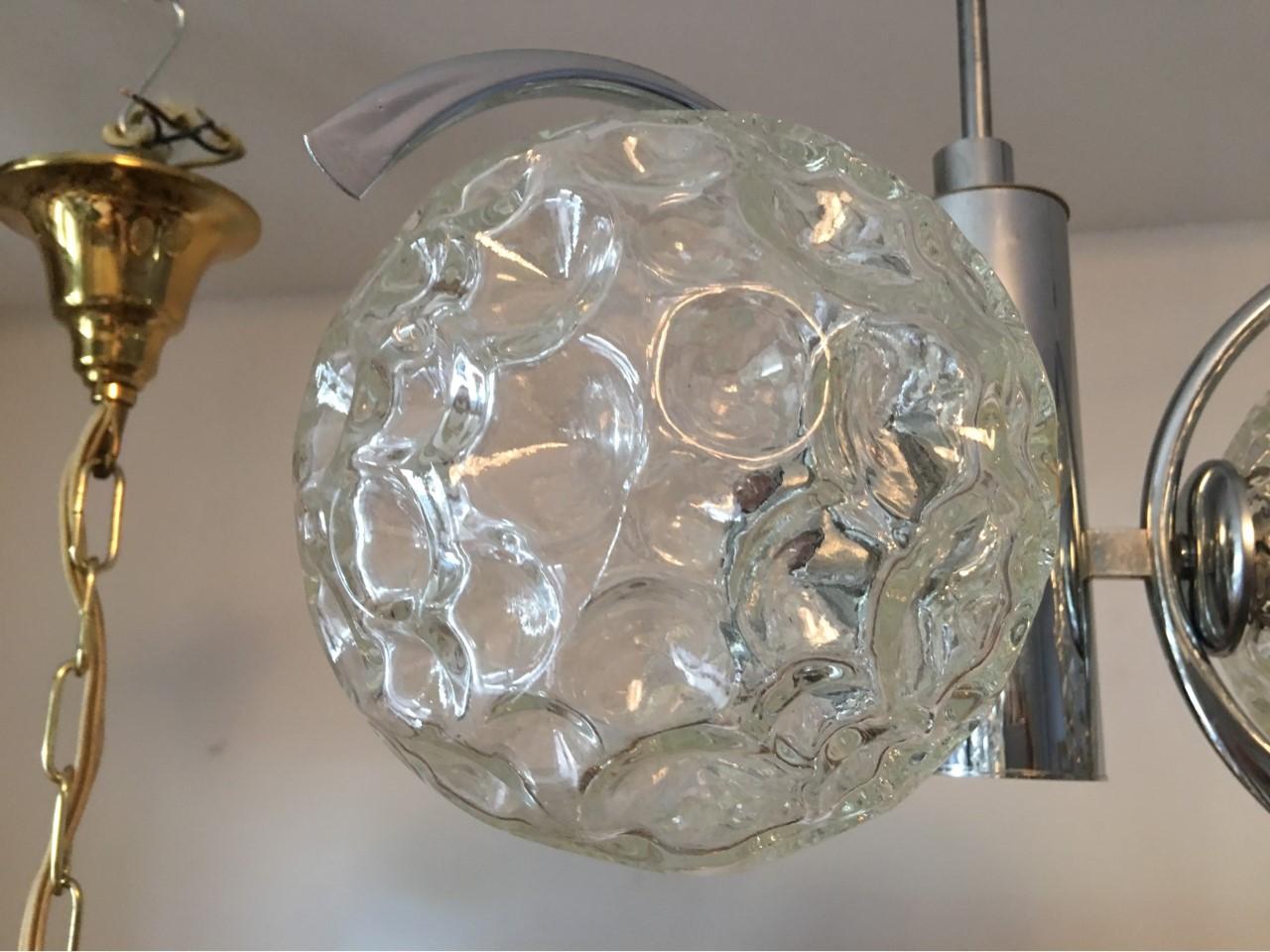 From 1960s Italy. A lovely chandelier in chrome with three cratered glass balls creating lovely lighting effect. The fixture requires three European E14 candelabra bulbs, each bulb up to 40 watts. In good working condition. Equipped with original
