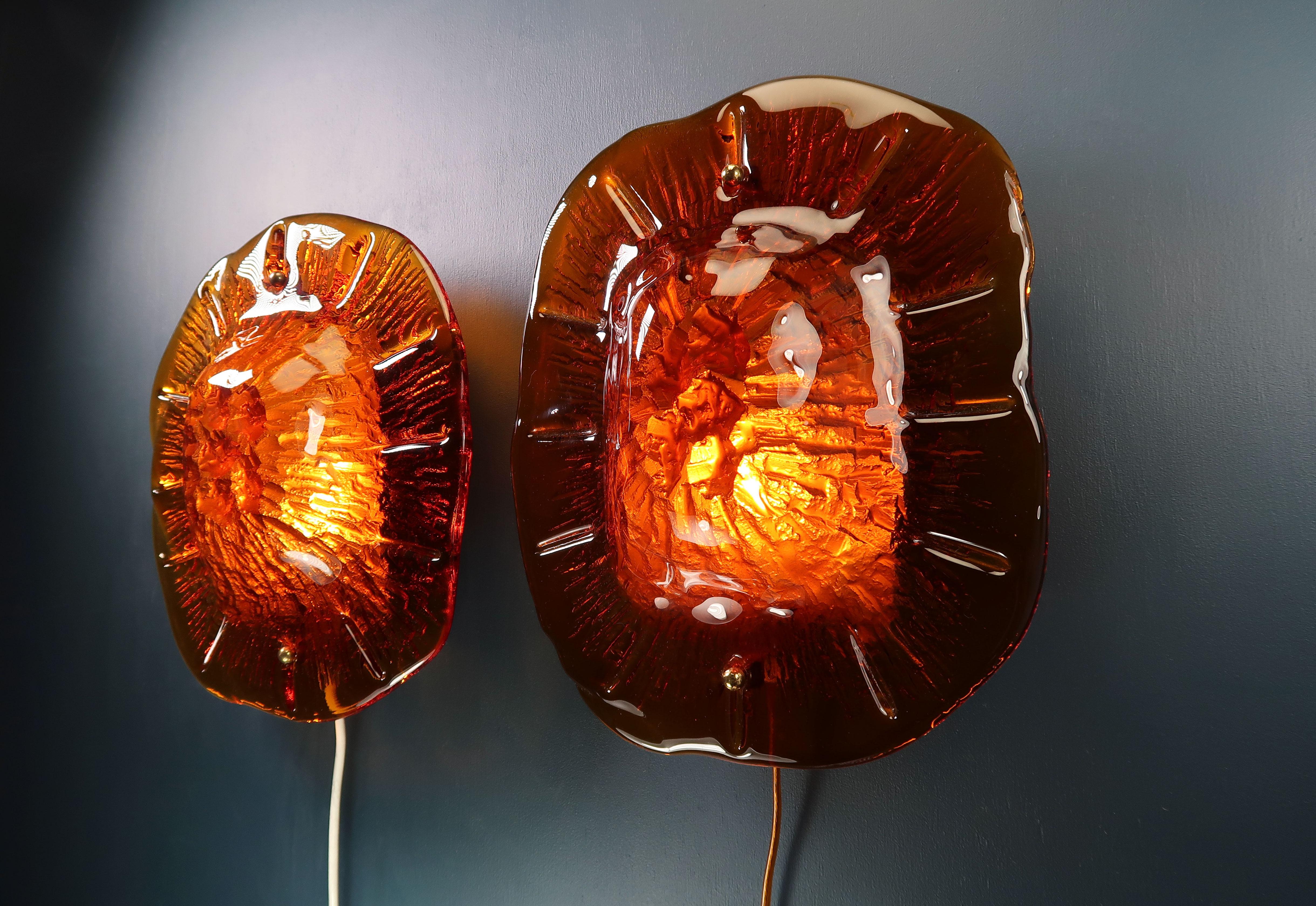 Three spectacular and rarely seen Danish modern wall lights composed of thick textured deep orange art glass with brass hardware and metal base by Danish Vitrika. The lamp is sometimes referred to as the tortoise shell lamp because of the shape and