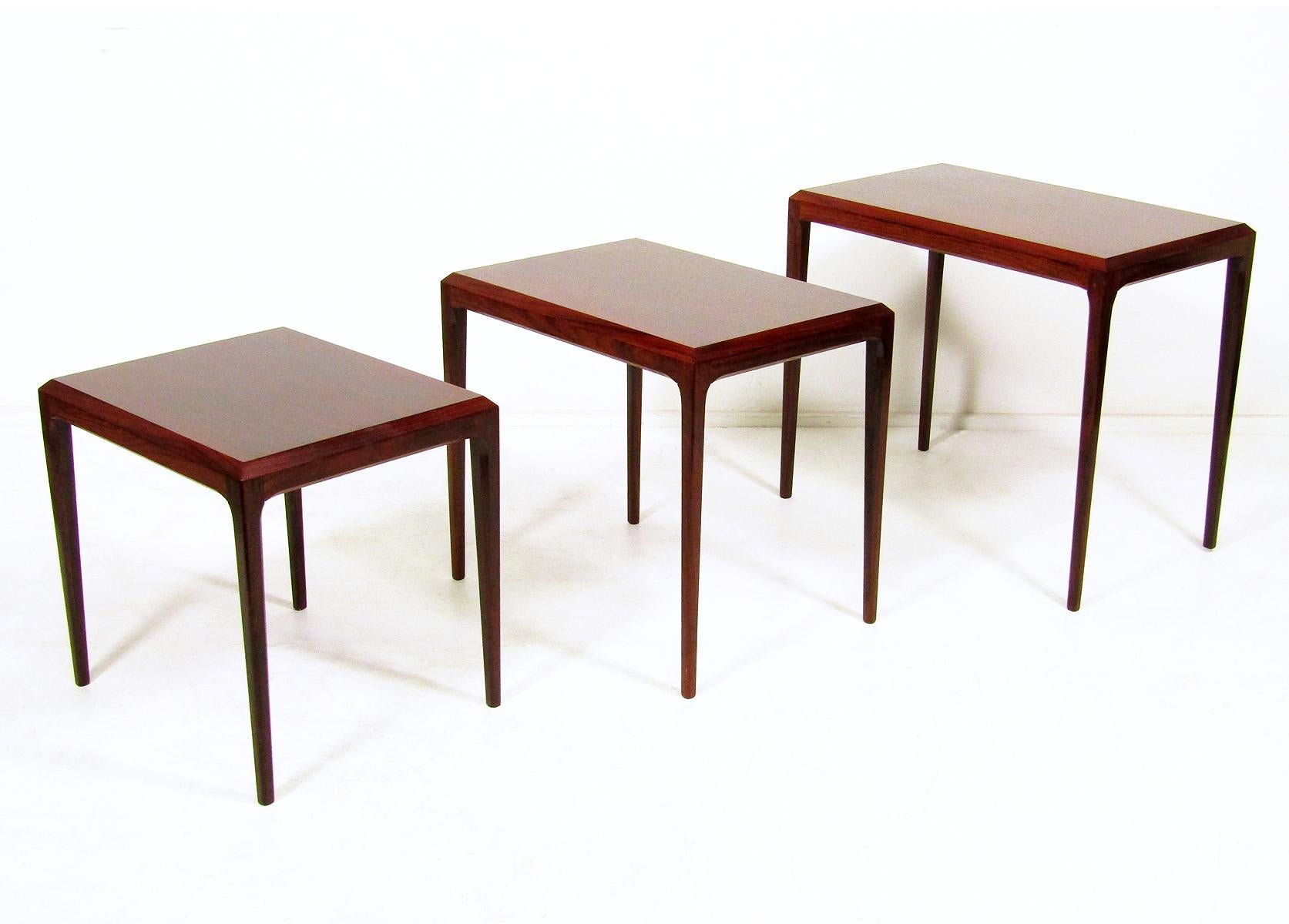 Ein Satz von drei Nisttischen aus Palisanderholz aus den frühen 1960er Jahren von dem dänischen Designer Johannes Andersen für CFC Silkeborg.

Mit feinen Proportionen, konisch zulaufenden Beinen und skulpturalen Konturen zeigen diese Tische die