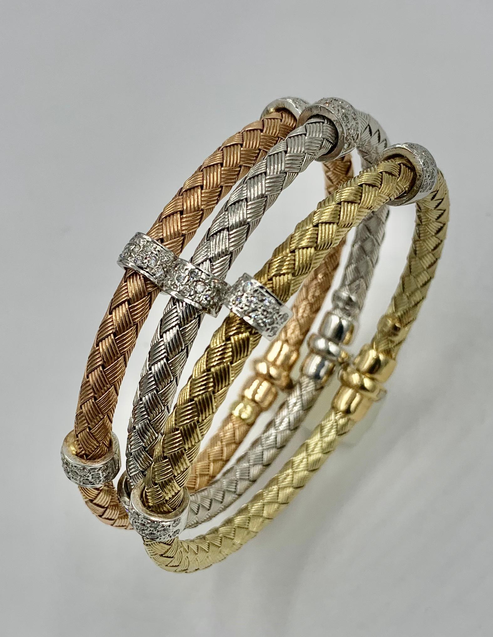 A wonderful and classic trio of three Braided Bangle Bracelets in 14 Karat Yellow, Rose and White Gold set with Diamond Rondelles.  The classic stacking Bracelets are Italian.  They have a stunning braided cable design, one in 14 Karat Rose Gold,