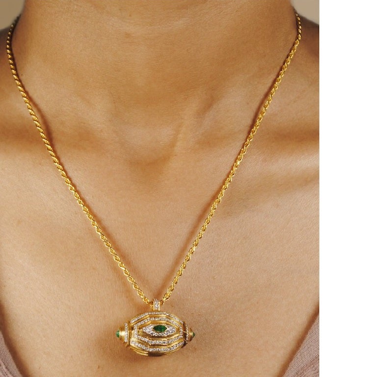 Cette exquise amulette Tawiz en émeraude est un contenant tridimensionnel magnifiquement travaillé, conçu pour protéger et préserver le pouvoir des messages magiques qu'elle renferme. Pesant 15,05 grammes et réalisé en or 18KT (14,78 gm), ce vase