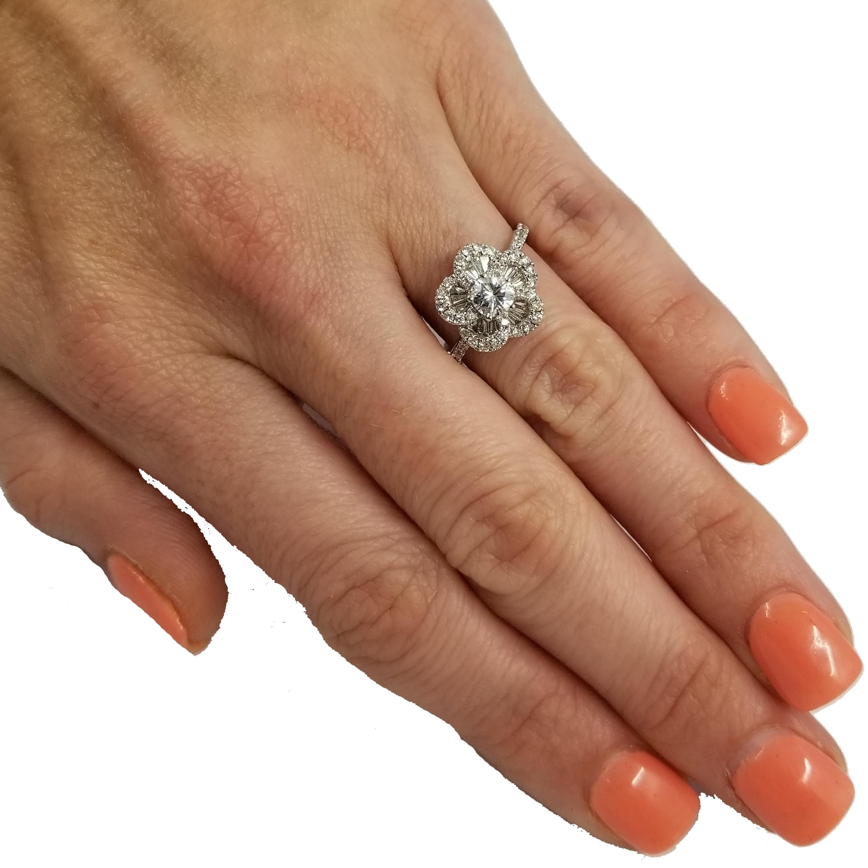 18 Karat White Gold Flower Ring Featuring a 0.37 Carat Round Center Diamond of VS1 Clarity & G Color. It is Surrounded by 15 Baguette Cut Diamonds Totaling 0.25 Carats, and 42 Round Diamond Totaling 0.38 Carats, Both of VS Clarity & G Color.