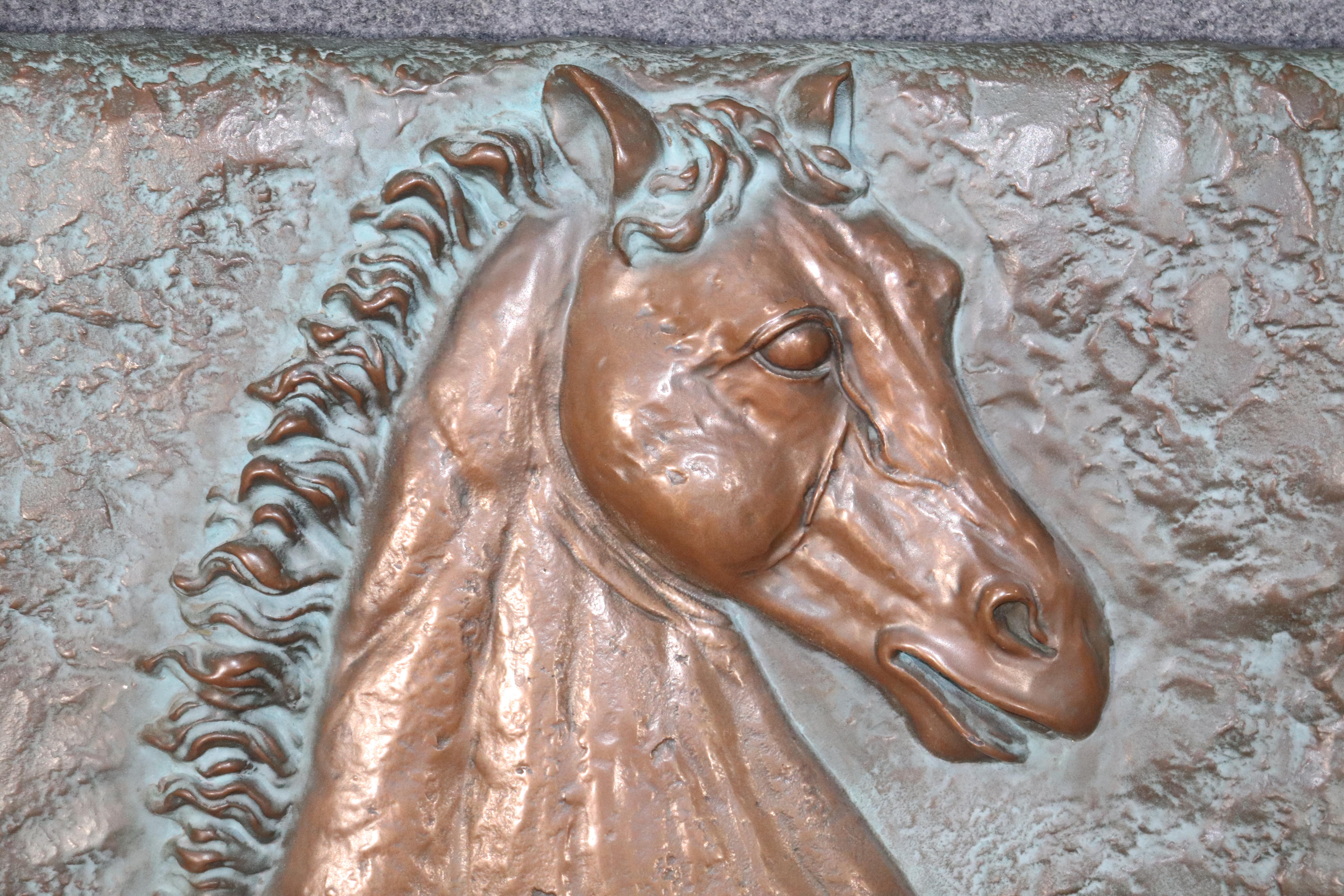 3-D relief artwork of a stallion painted in copper color.
Please confirm location.