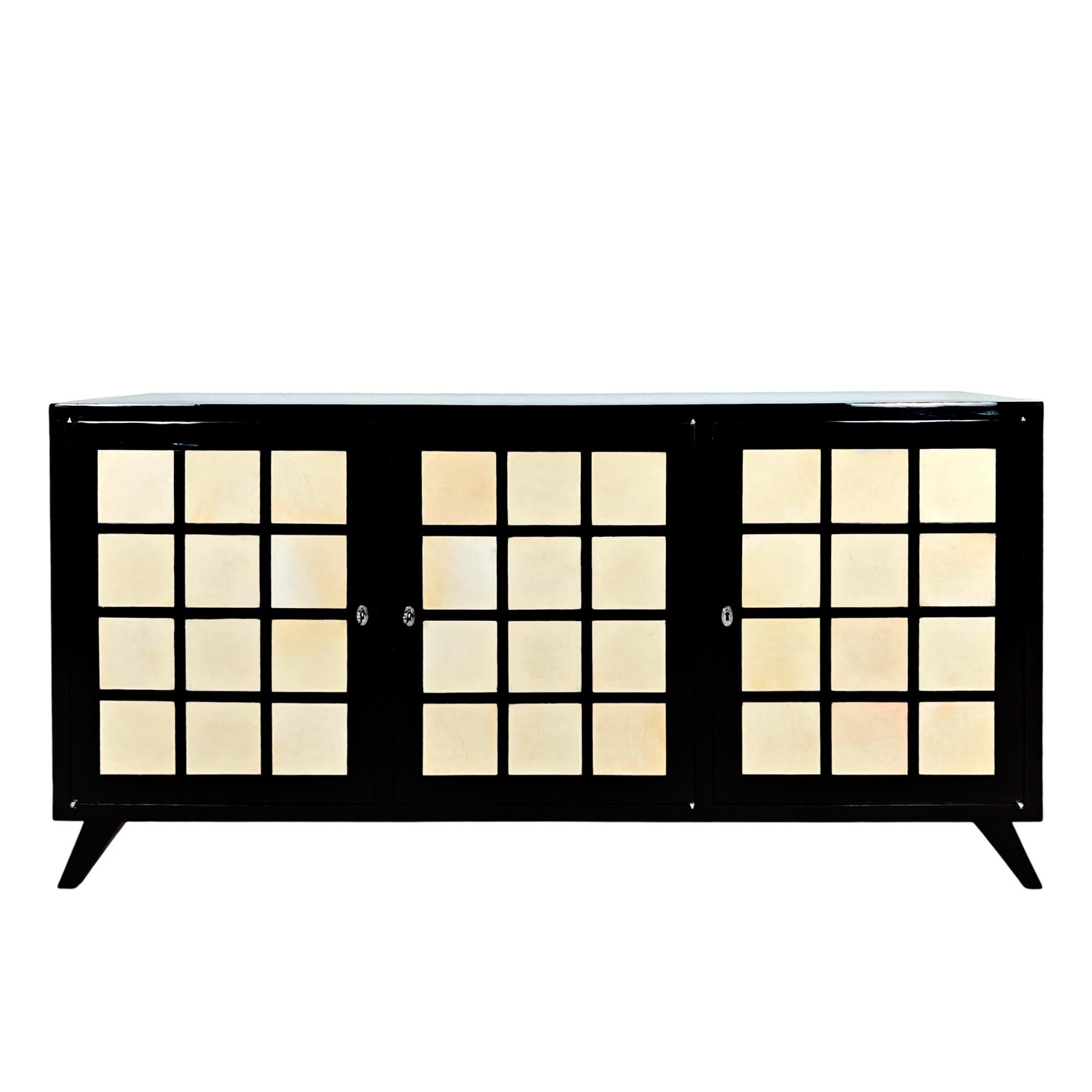 Dreitüriges Sideboard aus massivem, gebeiztem Kirschbaumholz, französisch poliert und mit 36 Pergamentquadraten verziert. Tasten aus vernickeltem Messing.

Italien, um 1940.