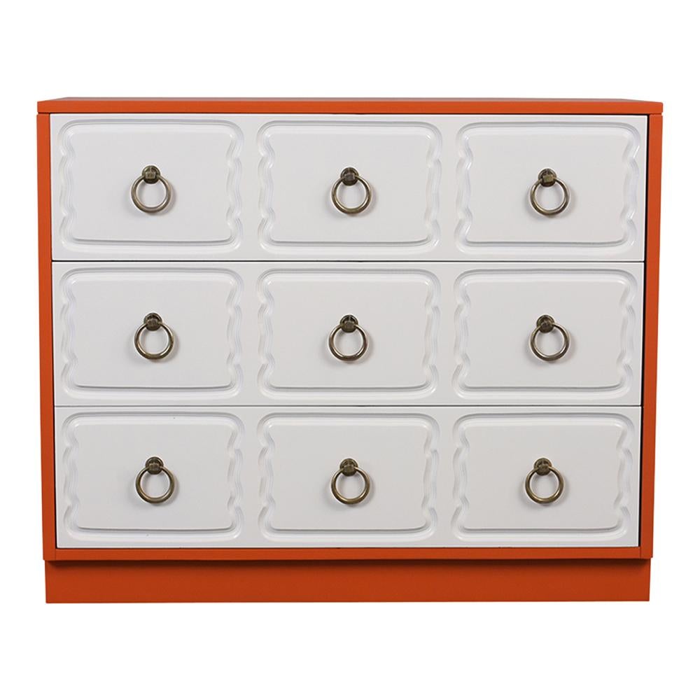 This Dorothy Draper Style Chest of Drawers has been fully restored. It features a unique orange and white color combination with a flat shine lacquered finish. The chest has three large drawers and engraved panels and brass circular pulls knobs. The