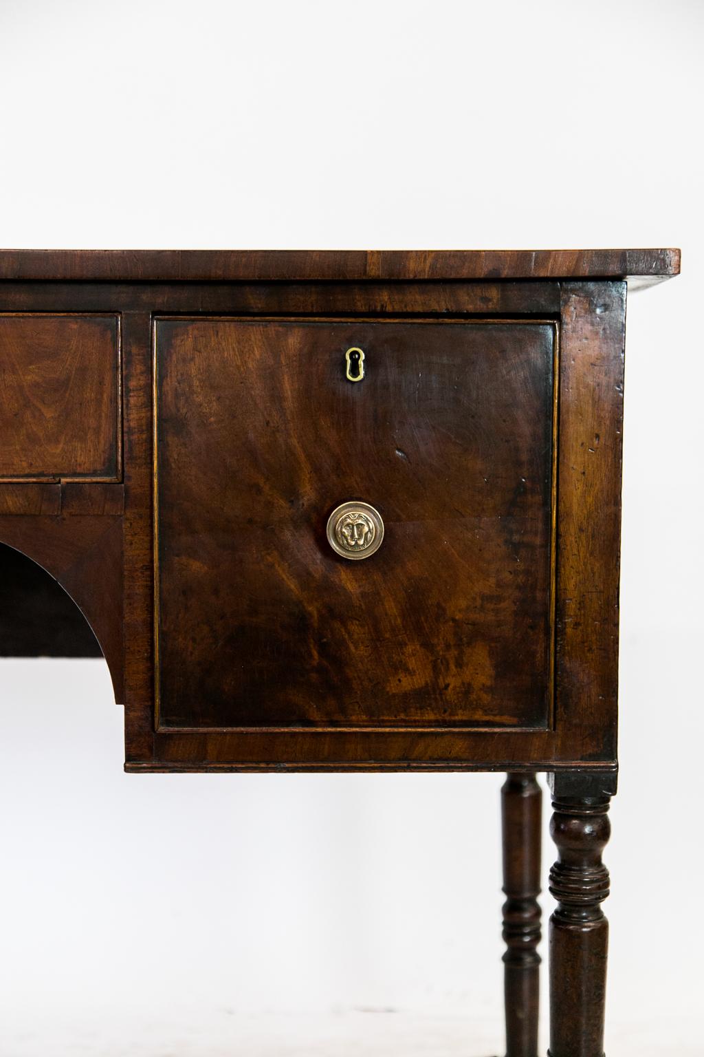 This early 19th century three-drawer English mahogany server has a center drawer with arched supports below. The drawers have cockbeaded edges and bullnose molding on the front and inside the arch. The four legs have multiple turnings.

      