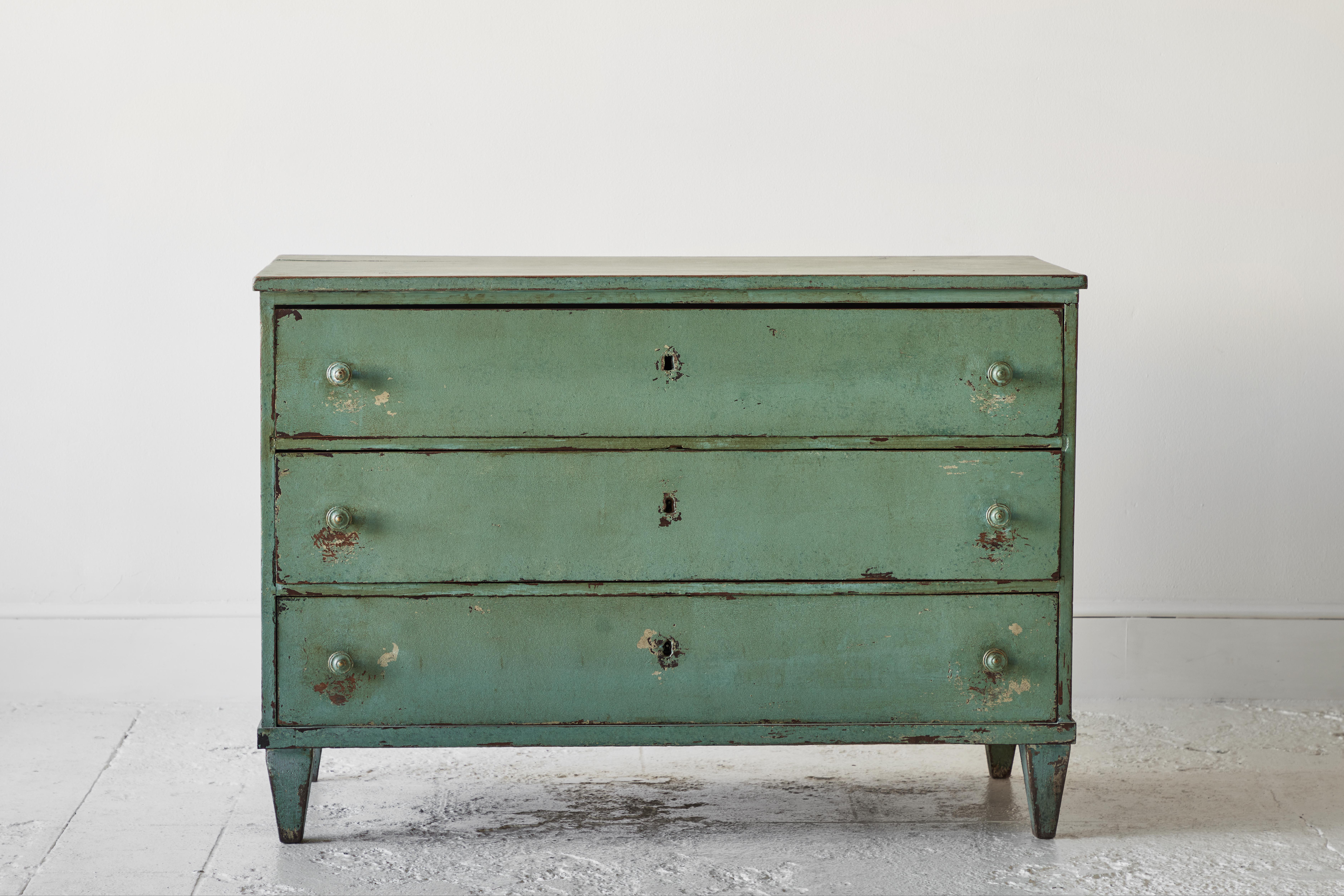 Three-drawer mint green painted dresser with four obelisk tapered legs.