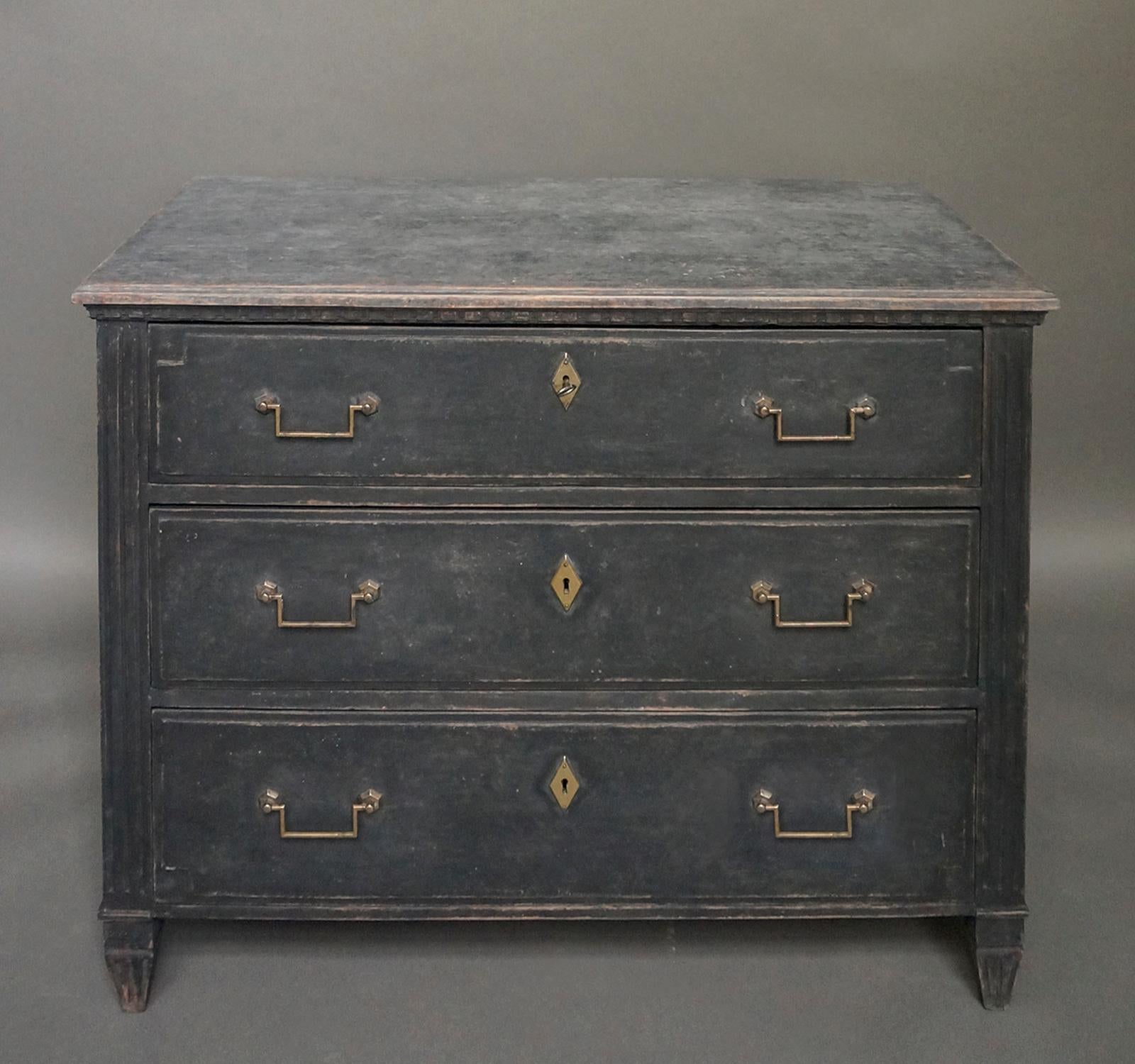 Black chest of drawers in the neoclassical style, Sweden, circa 1860. Shaped top with dentil molding and reeded corner posts above the tapering square feet. Nicely detailed raised panels on the drawer fronts. Original hardware.