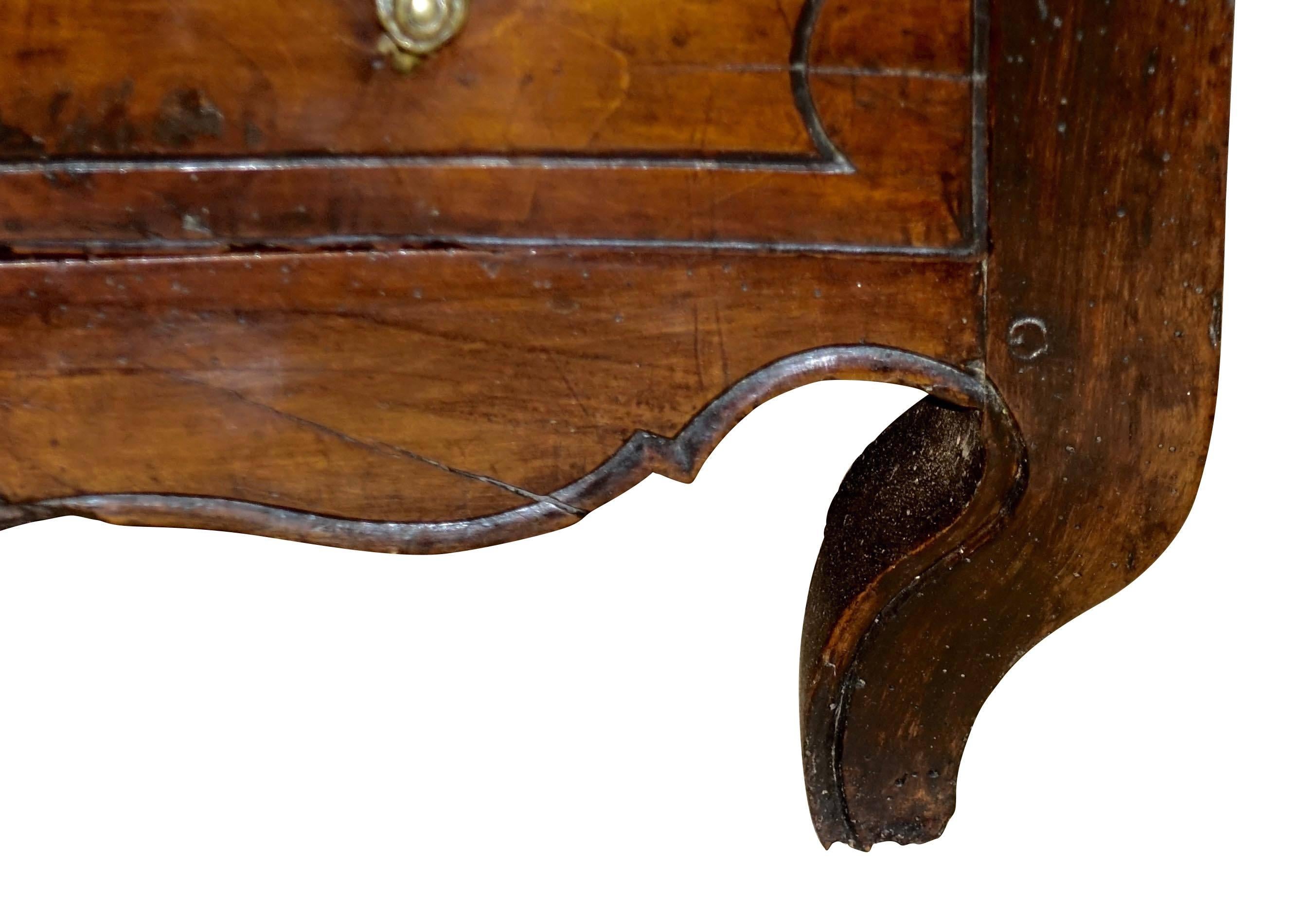 18th century French three-drawer walnut commode with original decorative brass hardware.
Concave bombe shape.
 