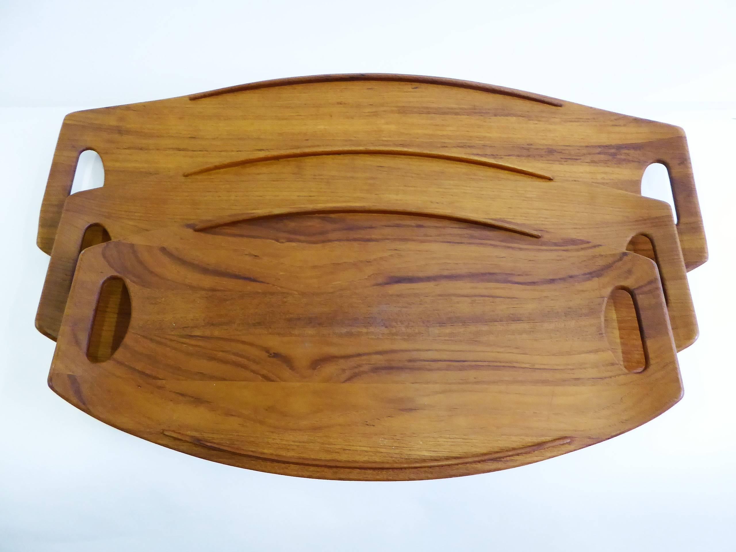 Three classic Fjord Teak Trays, designed in 1956 by Jens Quistgaard for Dansk Designs. All made in Denmark, with early Four Ducks Dansk logo and the larger two stamped also with 802 and 803. The 801, 802, and 803 teak trays which originally date