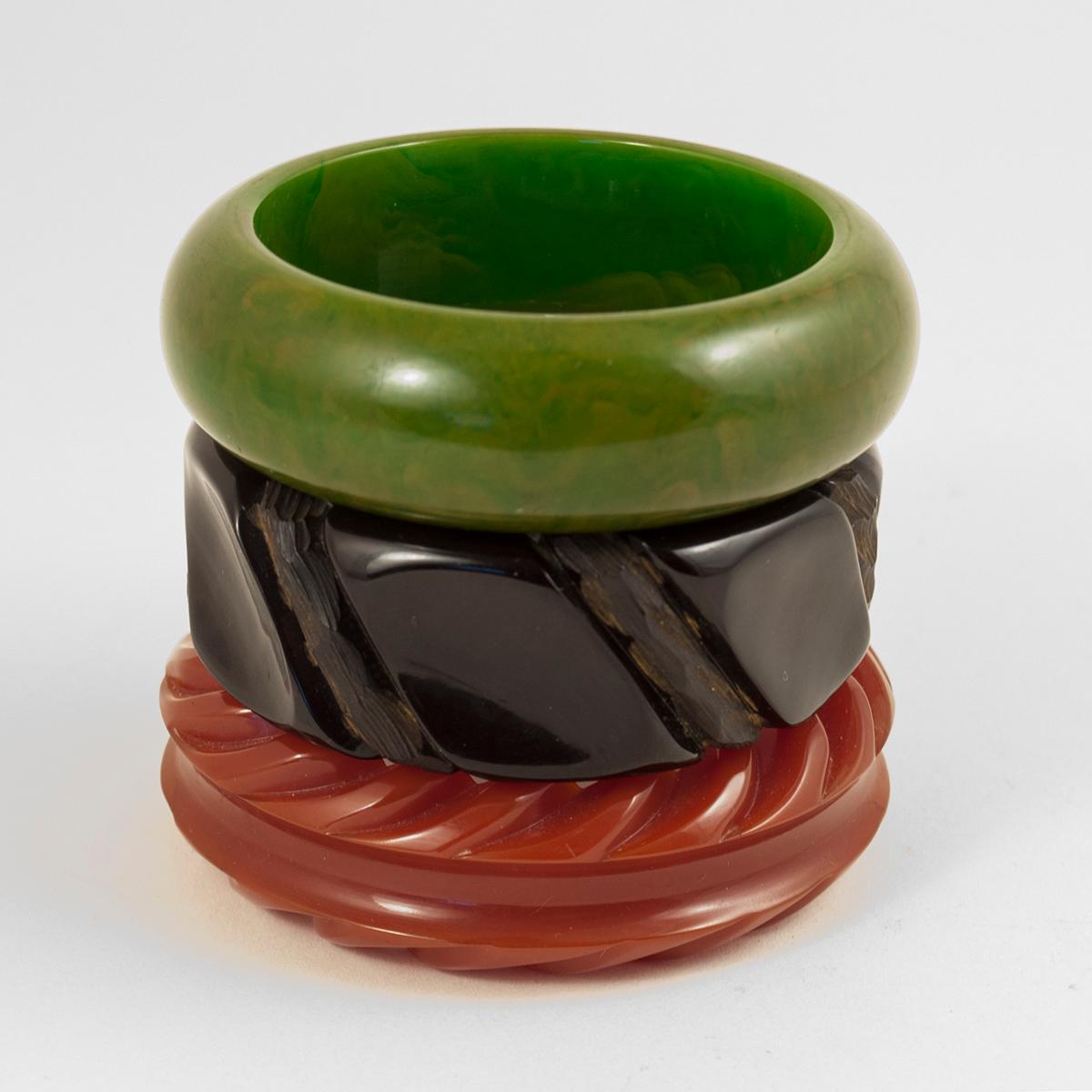 Tres pulseras de baquelita de principios a mediados del siglo XX

Tres fabulosos brazaletes de baquelita en perfectos colores navideños.
Verde oliva moteado  19,7 cm de circunferencia interior por 2,2 cm de ancho
Negro tallado a mano  20 cm de