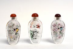 Three Églomisé Reverse Painted Snuff Bottles with Magnolia and Orchid