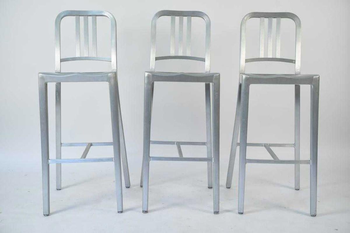 From the movie set of 'The Upside', these classic Emeco aluminum Navy bar stools designed by Philippe Starck was first built for use on US submarines in 1944. Stools have original round metal glide with a Lexan cap, for the Navy collection. For