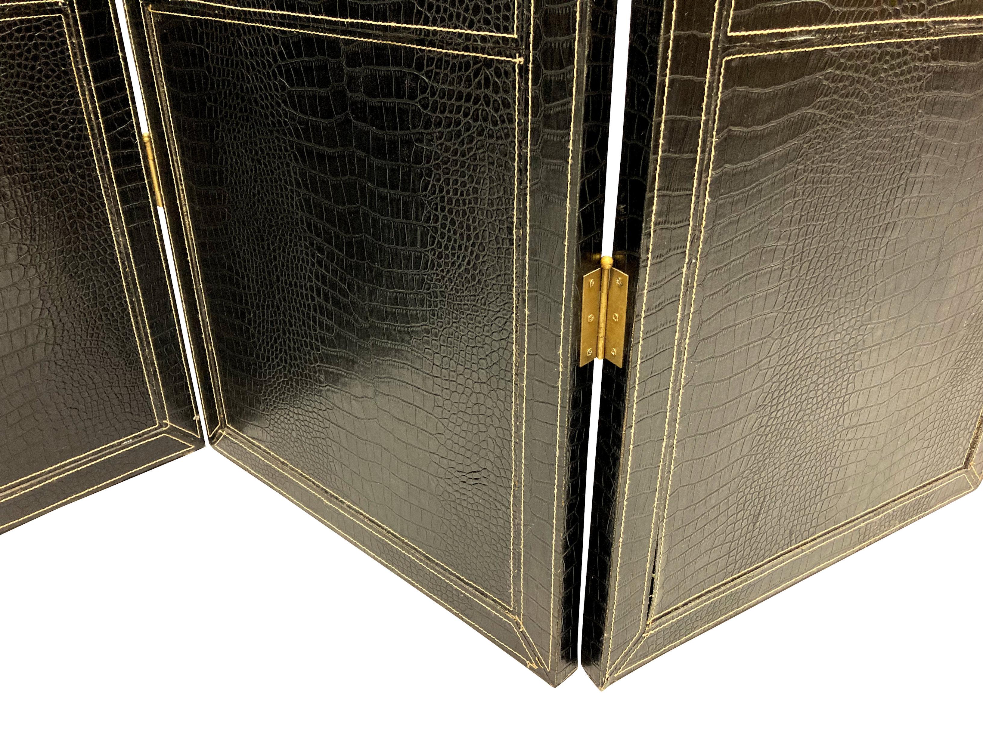 A French three fold room divider in hand stitched black crocodile skin. The reverse of plain dark wood, and with brass hinges.