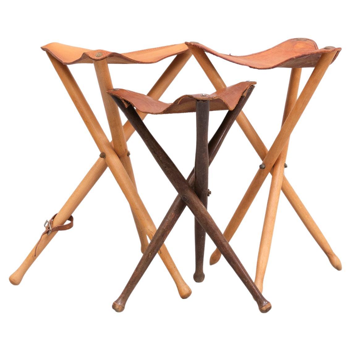 Three Vintage Scandinavian Tripod hunting stools with legs made of solid lacquered beech and Ash wood and a seat of thick tanned saddle leather. all slightly different.  Manufactured in the 1960s  