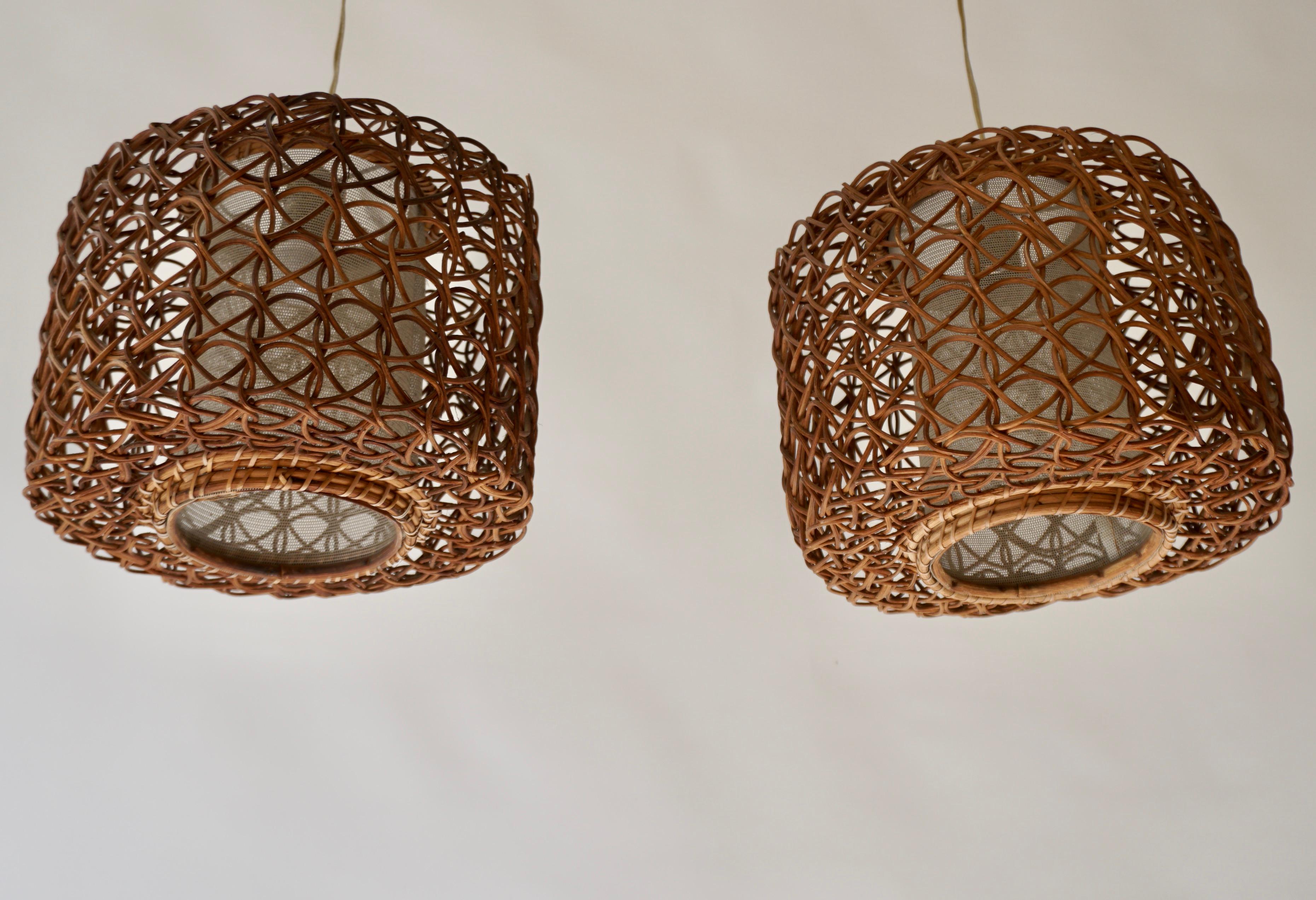 Trois lampes suspendues en rotin français avec un abat-jour intérieur avec une sorte de texture de lin. L'abat-jour intérieur est entouré d'une enveloppe ronde en rotin séparée.

Diamètre 11,4