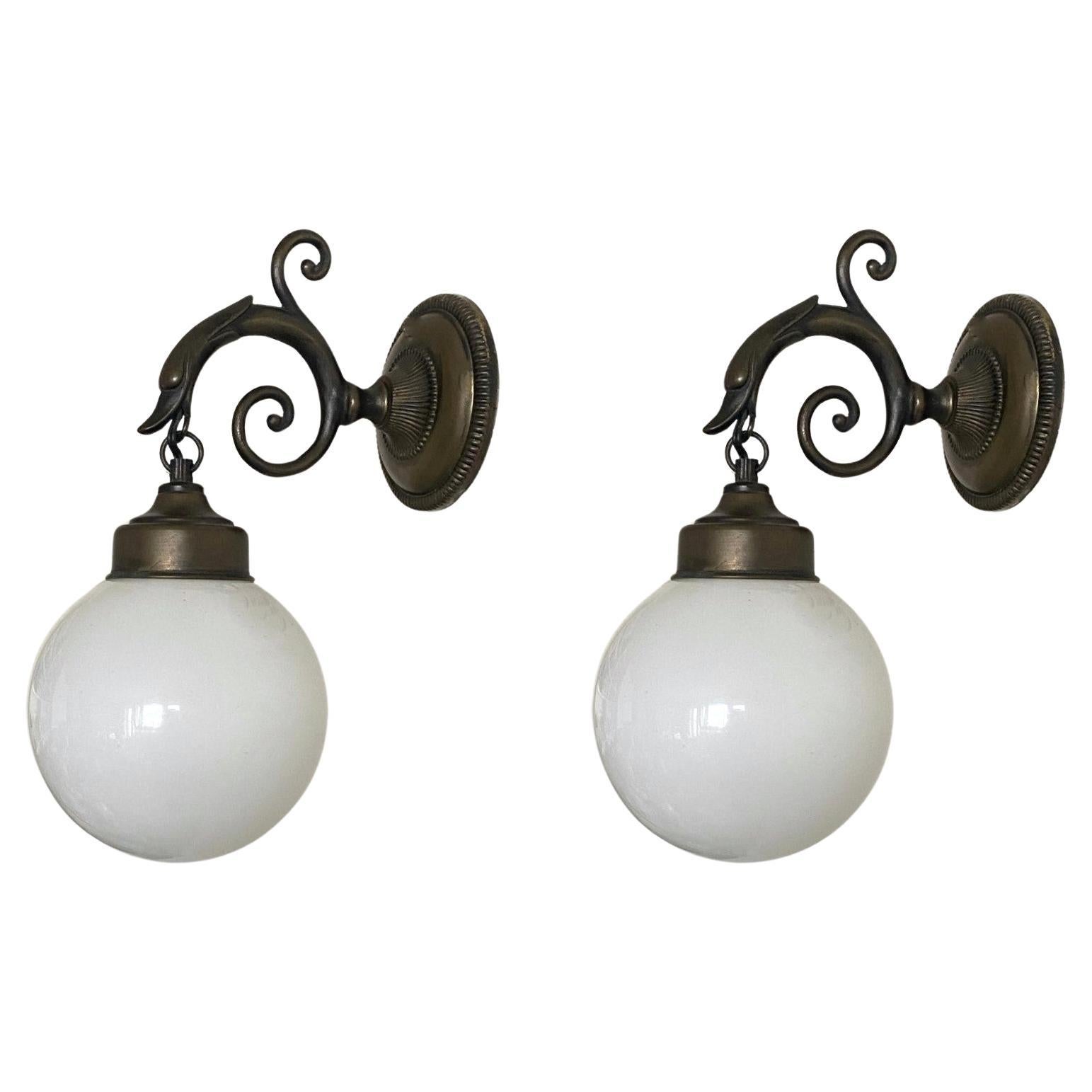 Set of three  lovely bronzed brass bird wall sconces with opaline glass ball globes, for indoor and outdoor use, France, 1930-1939.
All three pieces sconces are in very good condition, beautiful patina to brass, fully functional. Each sconce takes