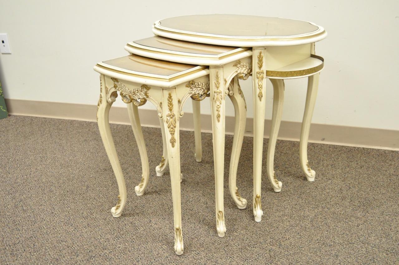 Set of three vintage French Louis XV style carved, painted, and satinwood inlaid nesting side tables. Item features beautifully carved bases, satinwood inlaid tops, custom fit inset removable glass tops, and elegant overall form, circa early to