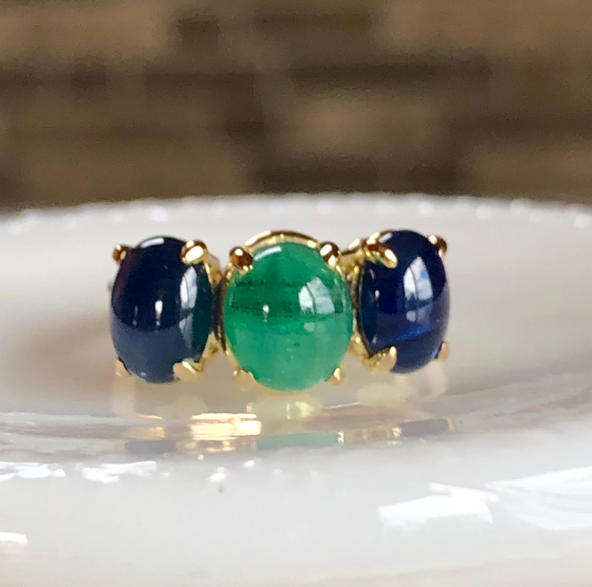 A bright colorful ring mount in the center, with one oval cabochon cut Colombian emerald of 1.90 carats.
Flanked at the sides, with a pair of oval cabochon cuts of Royal blue Sapphires, with a combined weight of 3.46 carats.
Total Gemstone weight