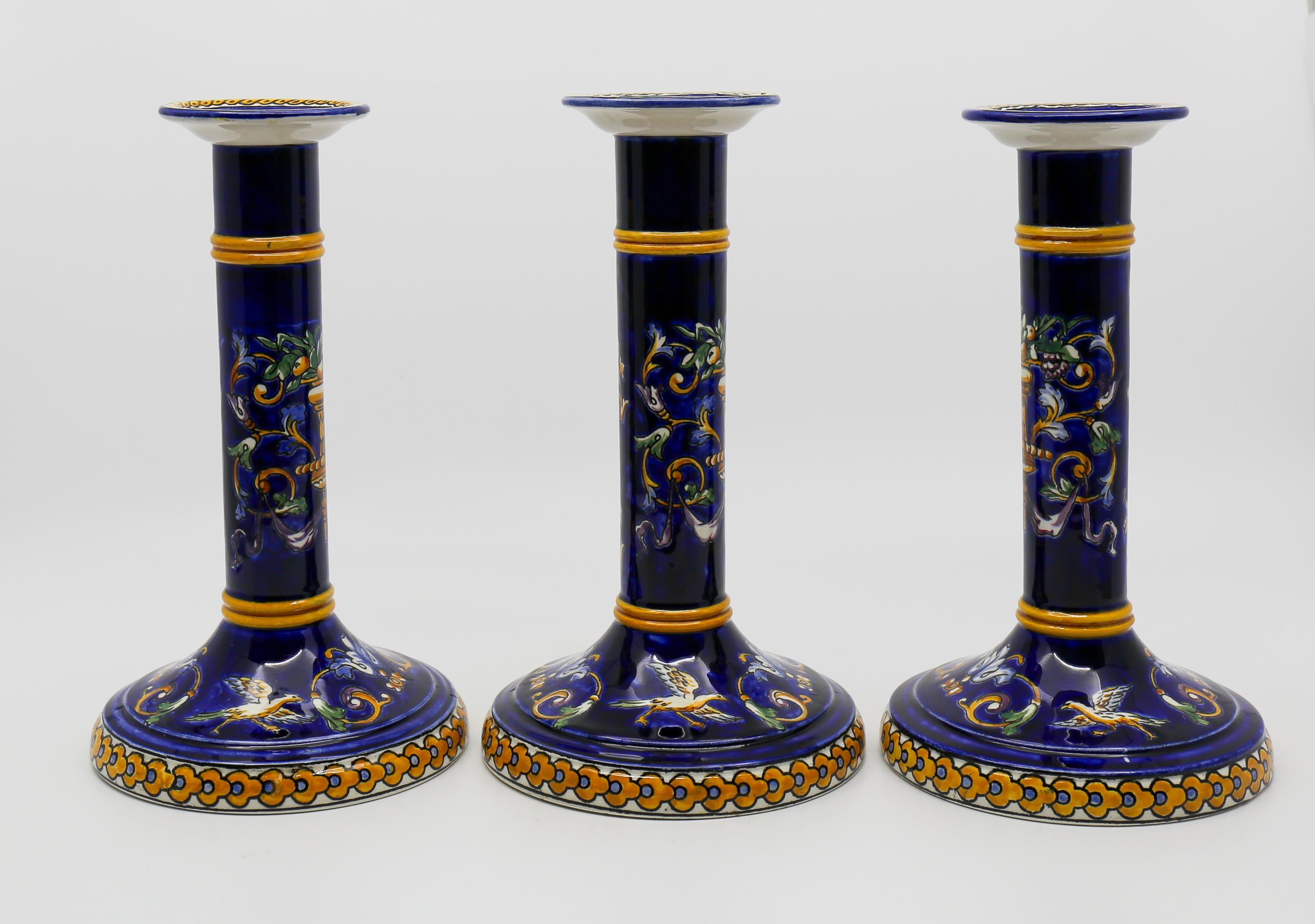 Three very beautiful Gien Renaissance model candlesticks in its night blue version. 
The base is cut out for a wire passage. Probably an adjustment to install a lamp. Apart from this small cut, no defect.