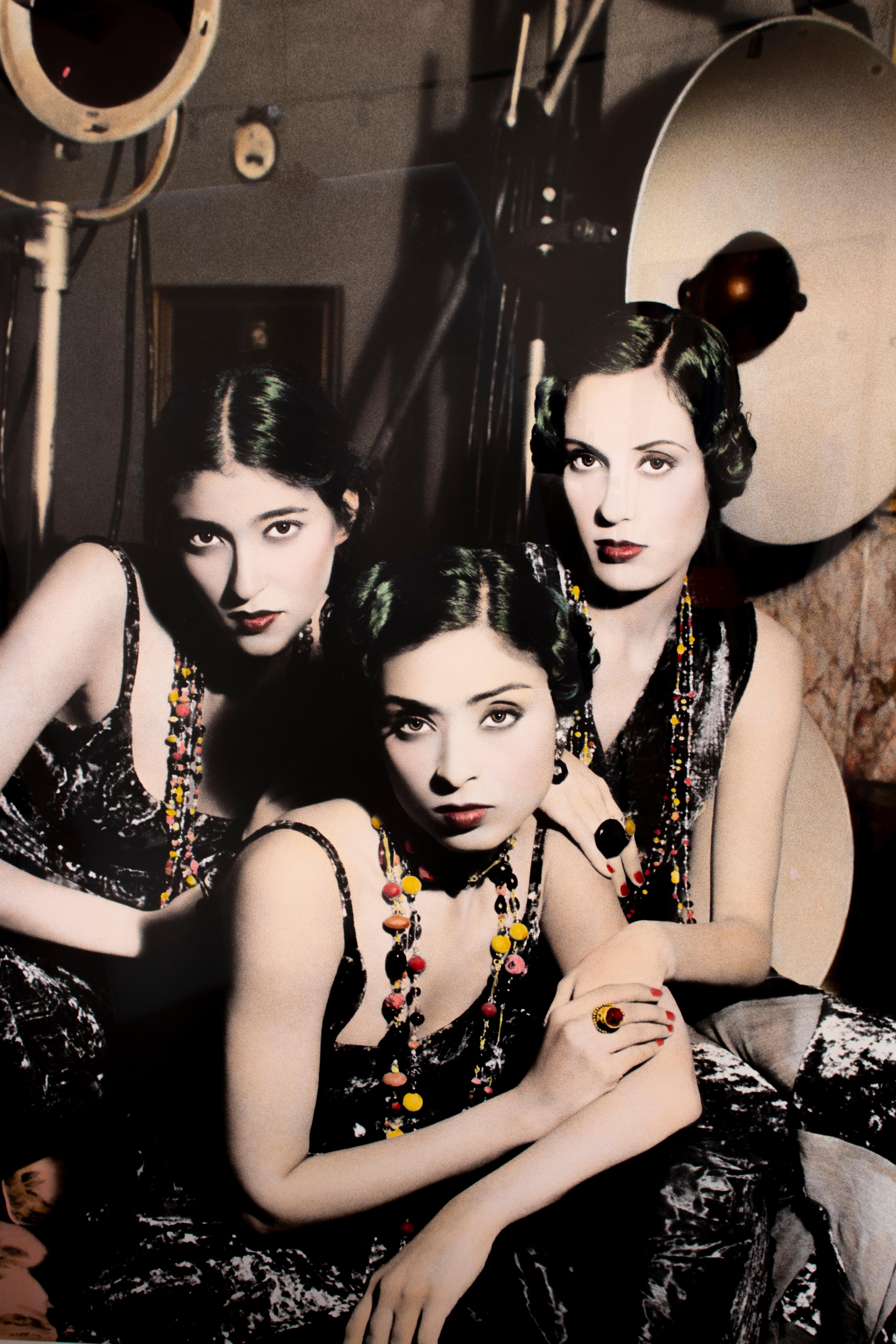 “Three Girls in Studio, Cairo” is a print of a Black and White photgraph by Youssef Nabil from 1993, hand-colored by the artist. Exhibition label at the verso states, that this print is number 2 of 3 in limited edition executed in 2000. The