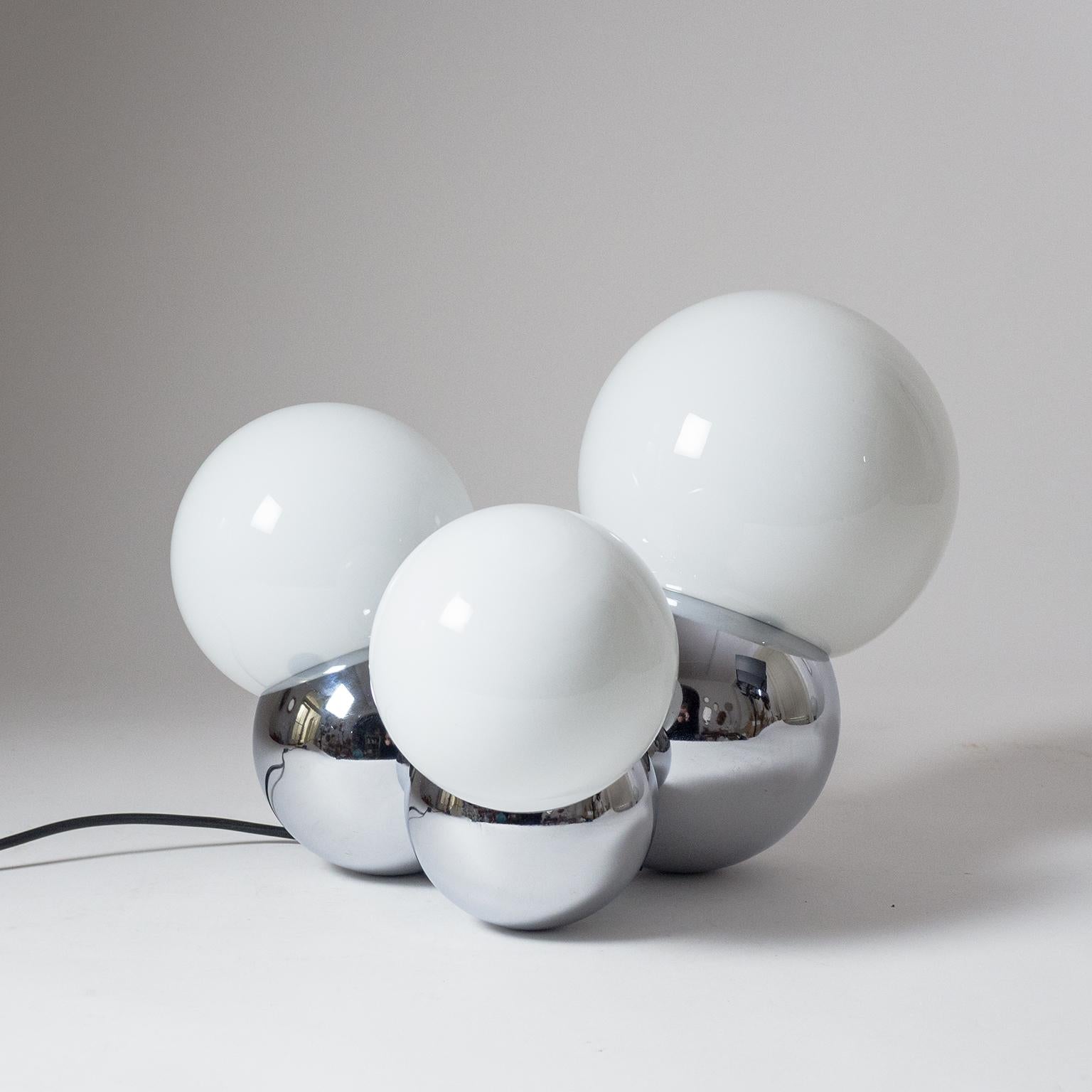 Stylish Italian Space Age table lamp with three chrome globes in varying sizes along with three blown opaline glass globes in corresponding dimensions attributed to Reggiani, 1960s. The lamp comes with an original multifunctional chord-switch which