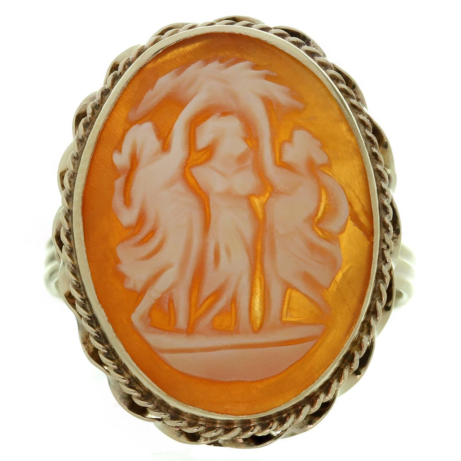 This elegant vintage ring is crafted in 14k yellow gold and features a beautiful shell cameo with a trio of female figures representing the three graces. Made in United States circa 1970s. Measurements: 0.70