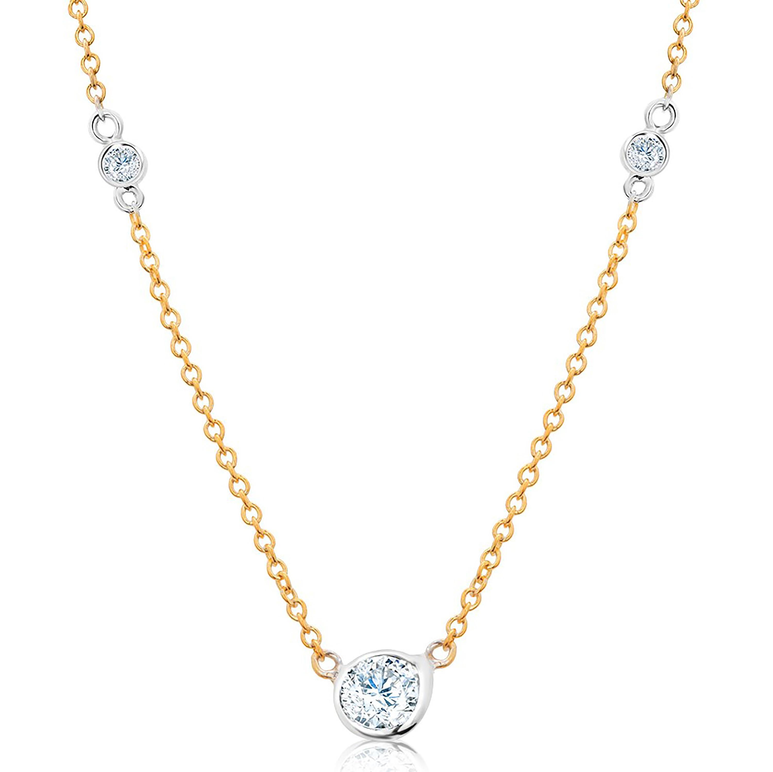 Fourteen karats white and yellow gold trending layered necklace pendant with three graduating bezel-set diamond 
Measuring 16 inches long
Center Diamond weighing 0.15 carat
Side Diamonds weigh 0.05 carat each 
Cable chain necklace with spring lock: