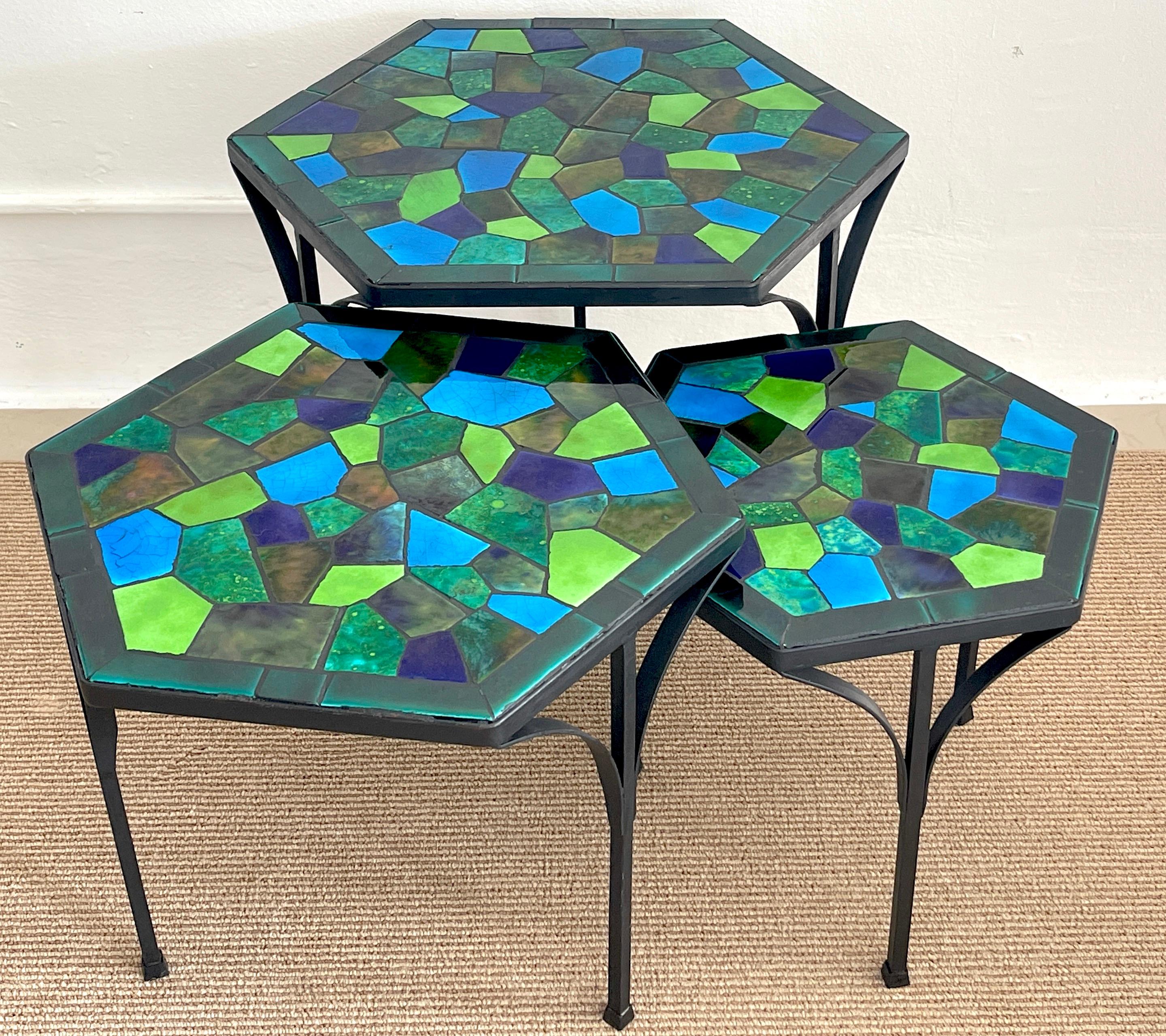 Three graduating wrought iron & ceramic mosaic tables by Jon Matin
Set of three hexagonal graduating tables, stunning blue and green color palette. Can use individually or group/ line up for a coffee table. 

Largest table 21